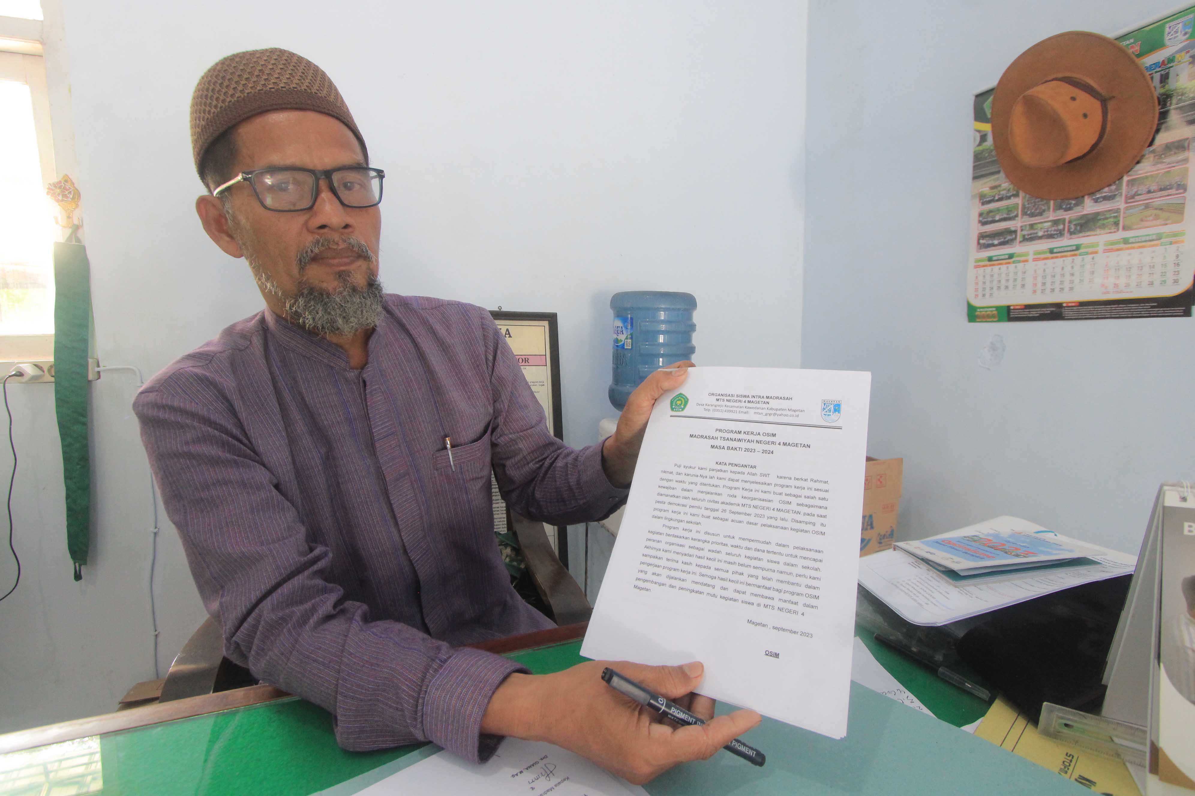KLARIFIKASI: Kepala MTsN 4 Magetan menunjukan data kegiatan Organisasi Siswa Madrasah (OSIM) di sekolah tersebut, kemarin (20/12). (AJI PUTRA/RADAR MAGETAN)