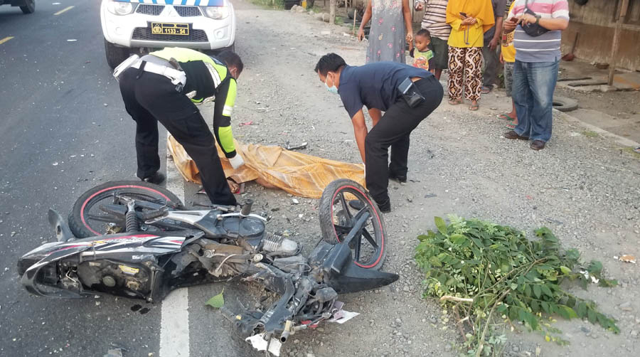KECELAKAAN MAUT: Polisi mengevakuasi korban kecelakaan maut antara bus Mira dengan motor di Jalan Raya Ngawi-Mantingan, Jumat (22/12) kemarin.&nbsp; (POLRES NGAWI UNTUK JAWA POS RADAR NGAWI)