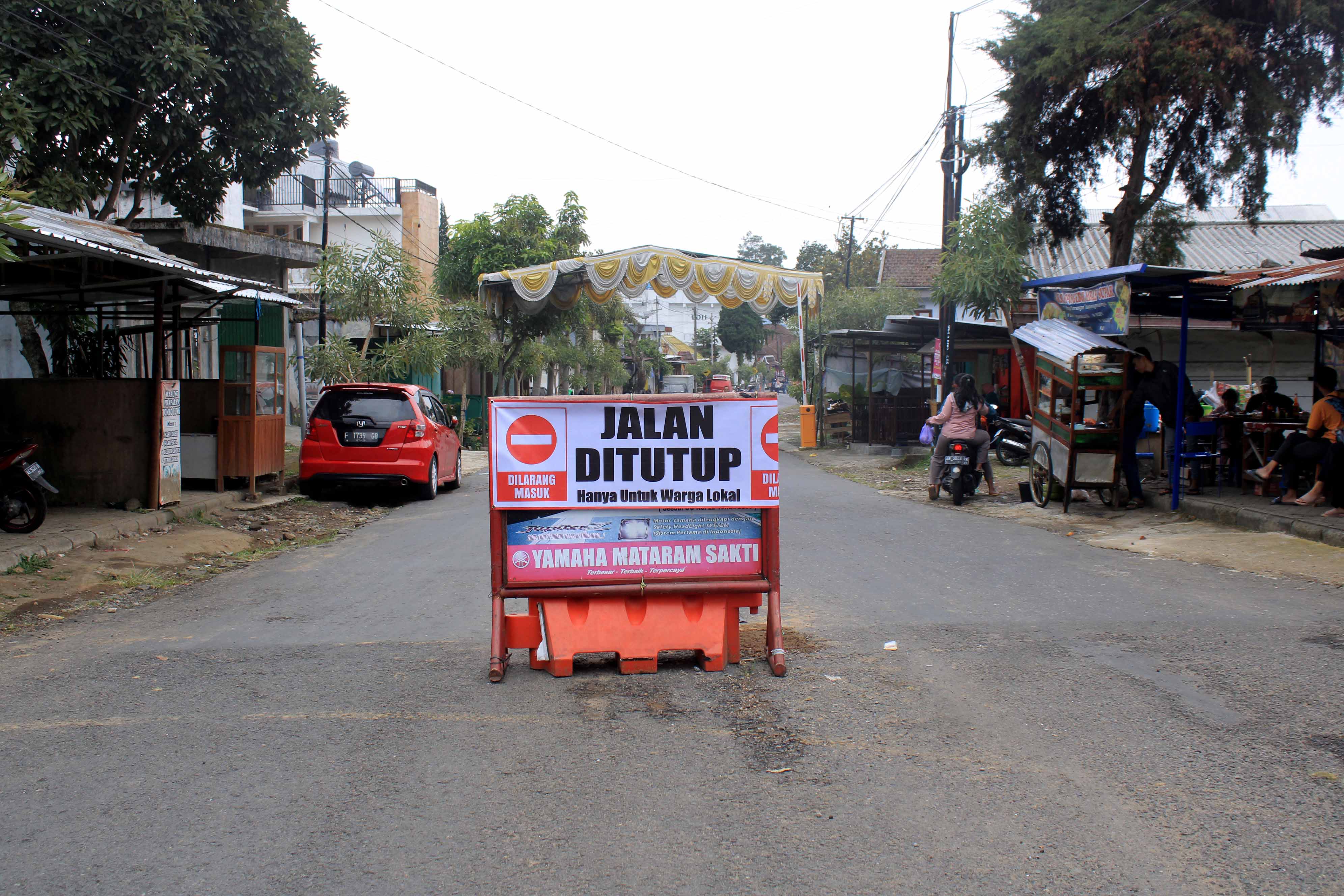 STOP: Para calon wisatawan menuju wisata Telaga Sarangan dilarang melintasi Jalan Ngerong-Sarangan lantaran rawan kecelakaan.&nbsp;(AJI PUTRA/RADAR MAGETAN)