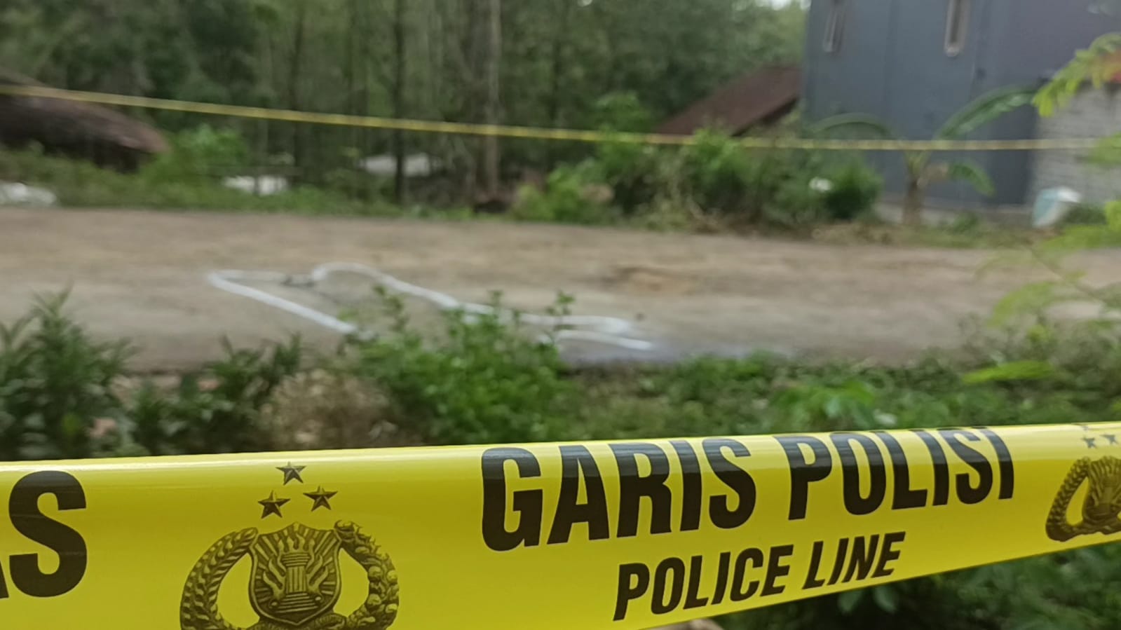 TKP: Lokasi pembunuhan di Desa/Kecamatan Pulung, Ponorogo, pada Senin (1/1) pagi dipasangi garis polisi. (SUGENG DWI/RADAR PONOROGO)