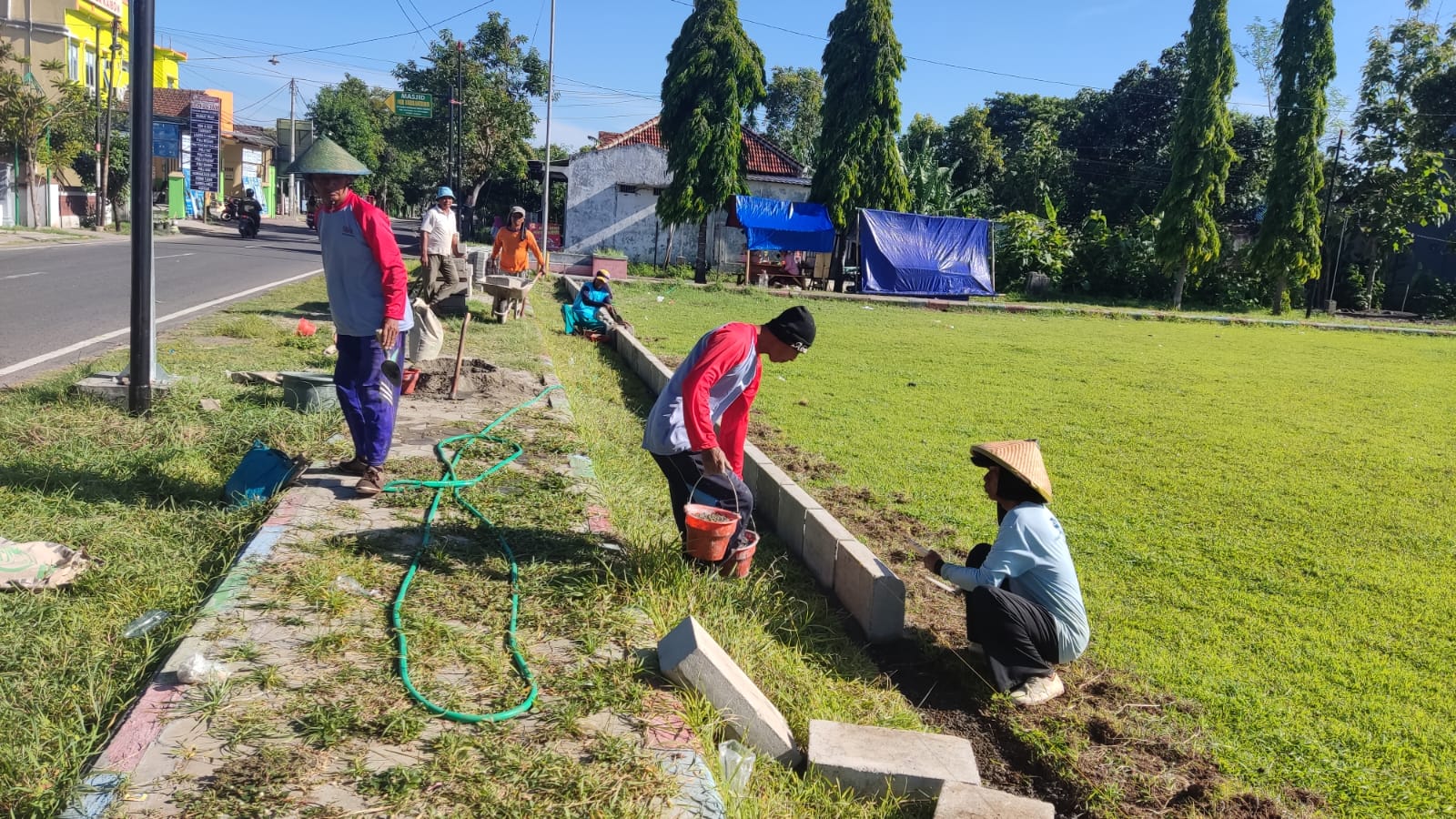 PROYEK: Sejumlah pekerja sedang melakukan pemasangan paving block yang berada di lapangan Desa Kaibon. (PEMDES KAIBON)