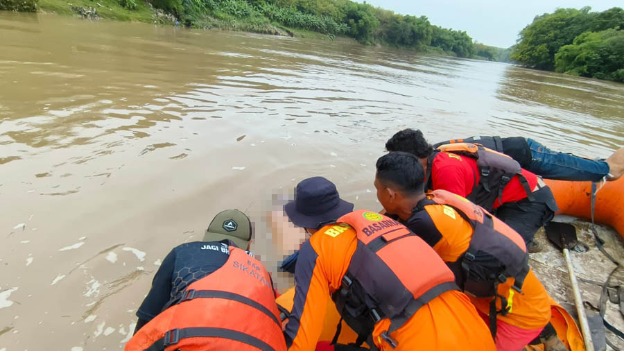 SUDAH TAK BERNYAWA: Petugas mengevakuasi jasad Bani yang tenggelam di aliran Bengawan Solo kemarin. (BASARNAS UNTUK JAWA POS RADAR NGAWI)
