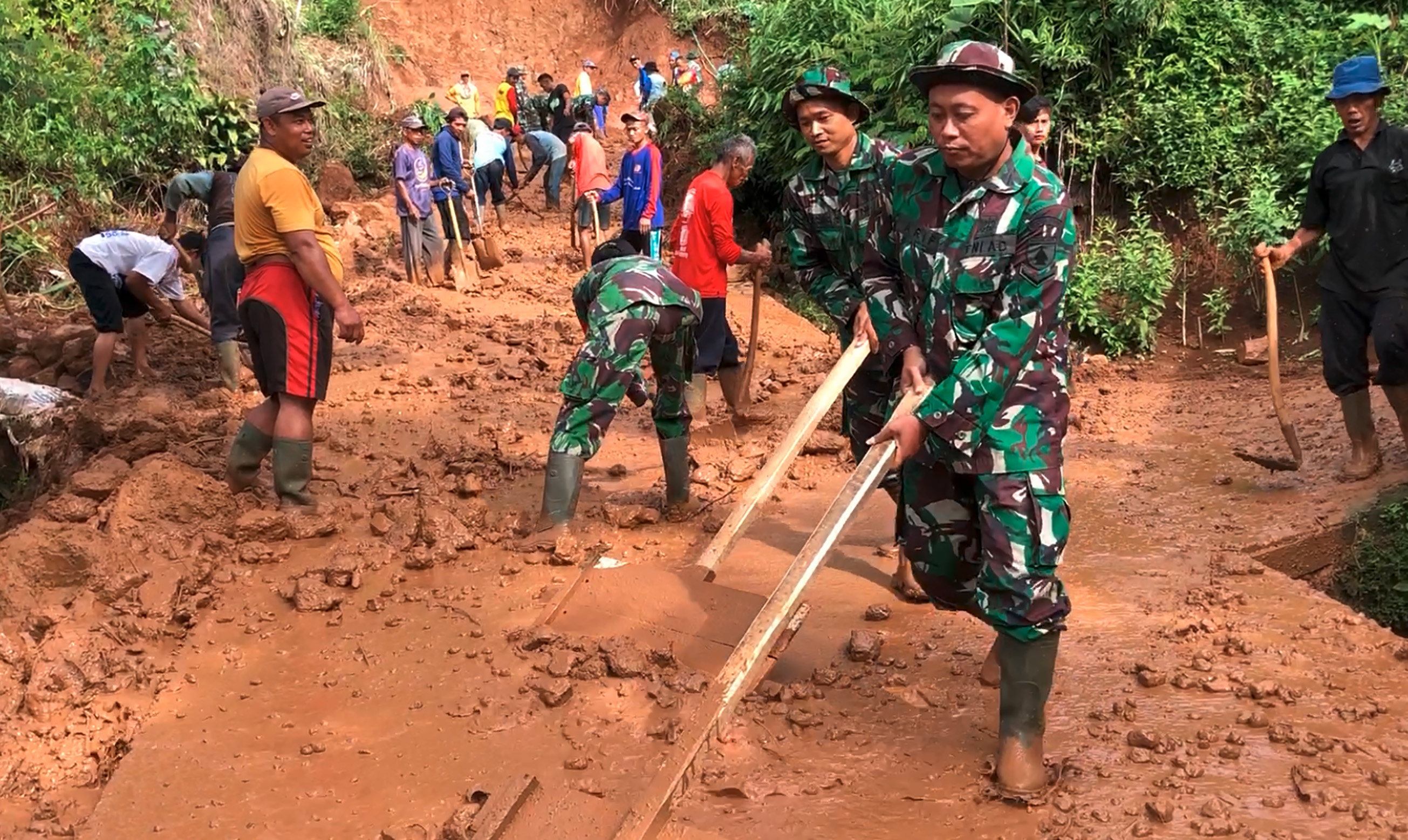 GERAK CEPAT: Petugas BPBD, TNI, Polri bersama warga gotong royong membersihkan sisa material longsor di Dusun Tangkil, Desa Banaran, Pulung kemarin (5/1).