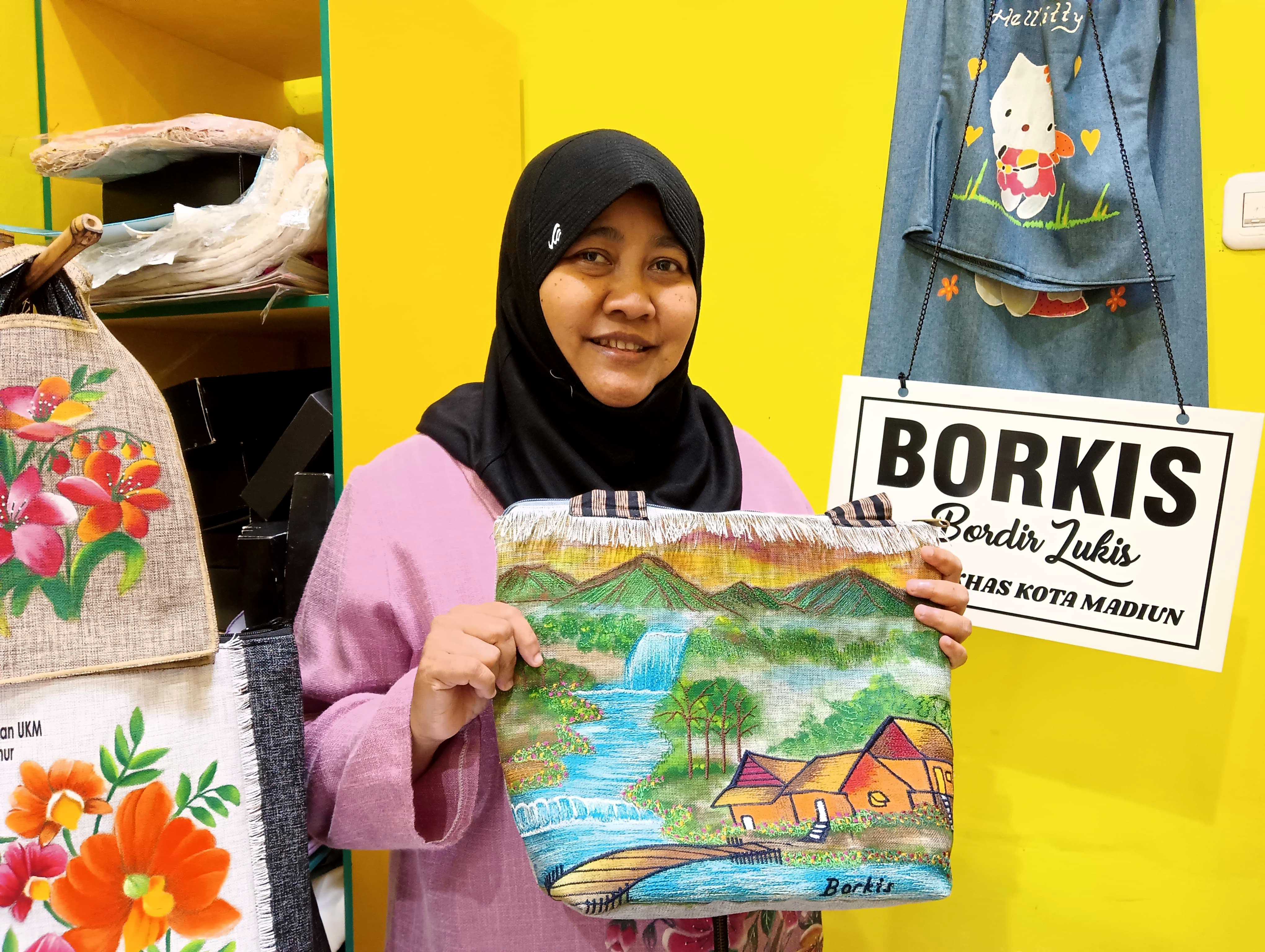 KREATIF: Heny Moerdaningsih menunjukkan salah satu tas borkis buatannya yang bermotif pemandangan.&nbsp;(ERLITA HERMININGSIH/RADAR MADIUN)