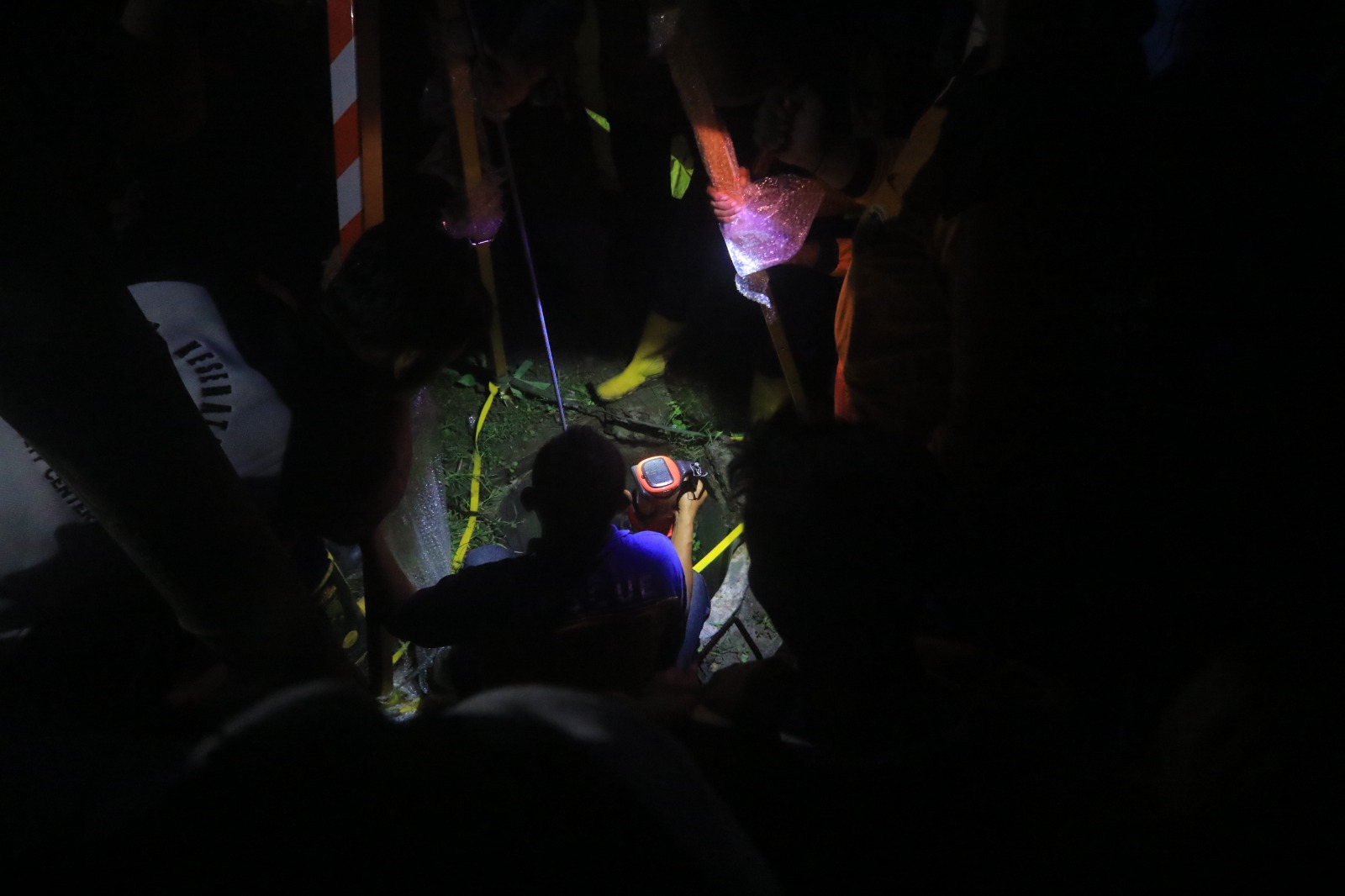 EVAKUASI: Petugas gabungan saat mengevakuasi korban tercemplung sumur di area persawahan Desa Banjarsari, Madiun, Minggu malam (7/1). (R. BAGUS RAHADI/JAWA POS RADAR CARUBAN)