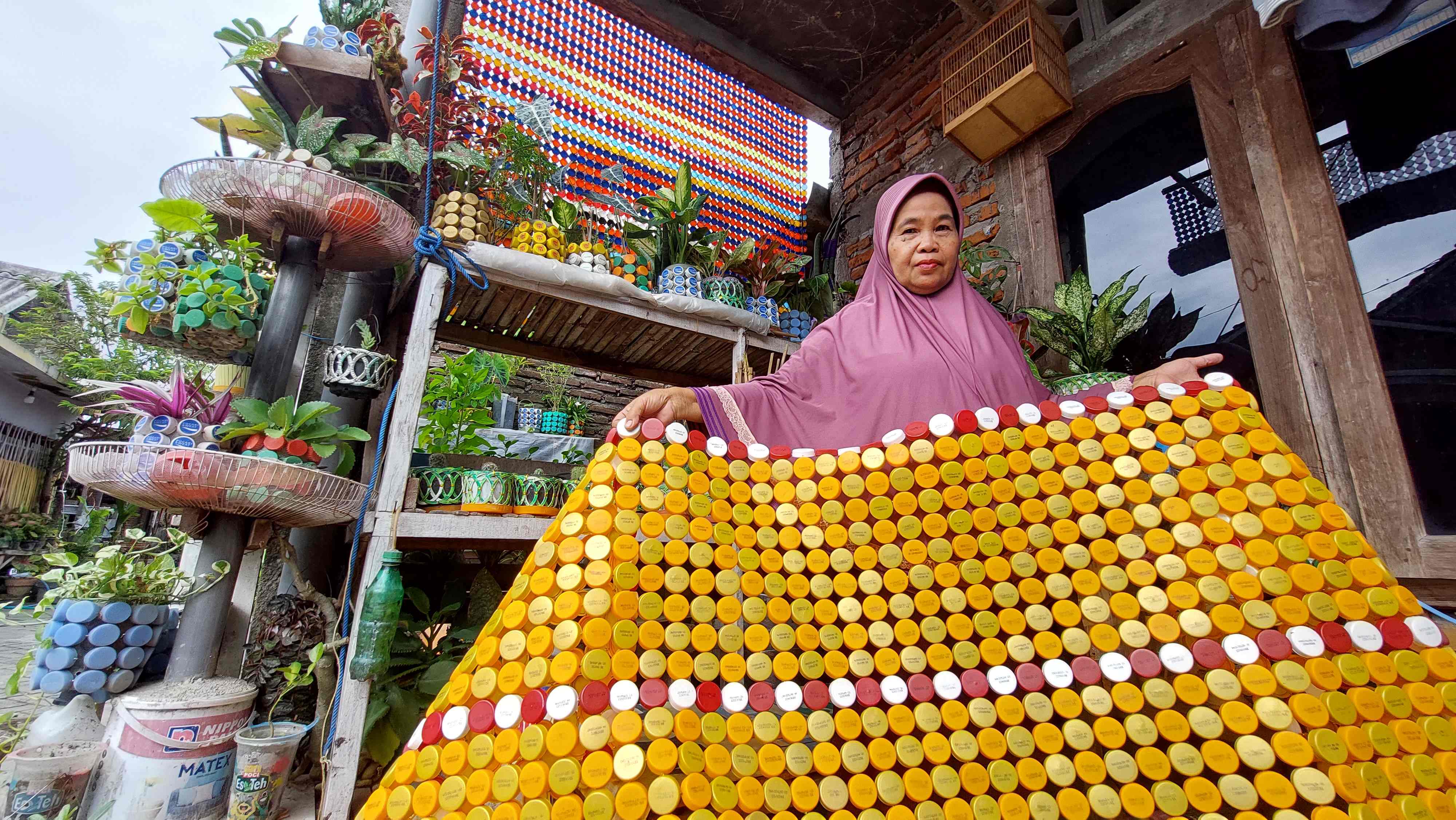 KREATIF: Surinah menunjukkan hasil kerai tutup botol setengah jadi buatannya.&nbsp;(DIAN RAHAYU/RADAR CARUBAN)