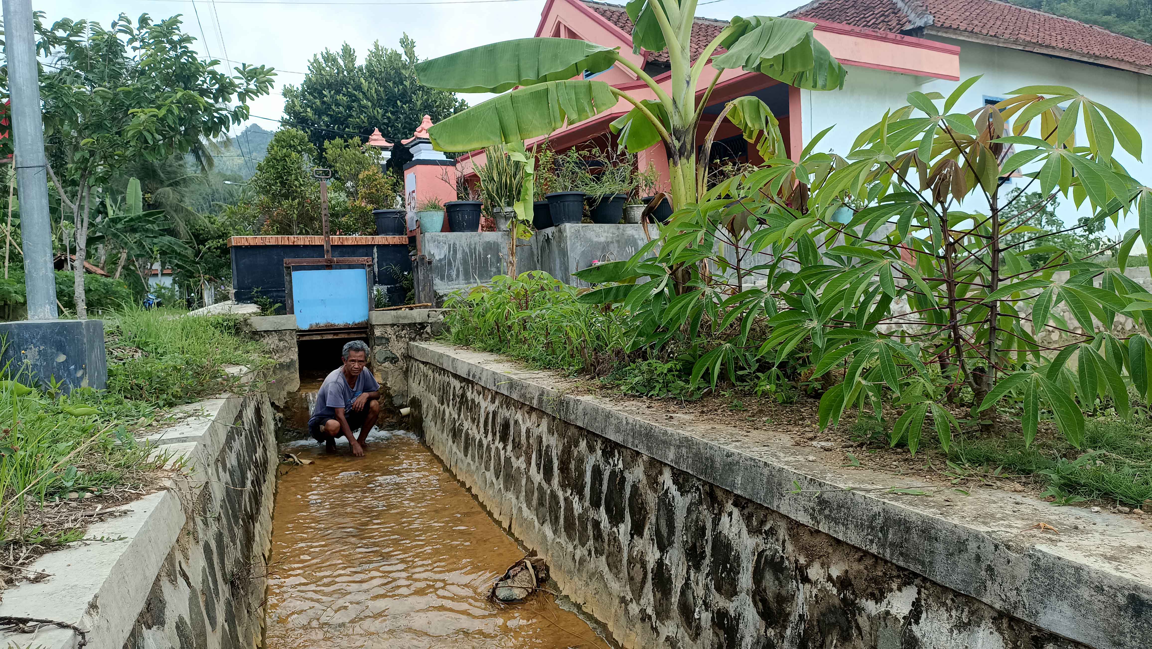 TERCEMAR: Warga Pacitan menunjukkan pencemaran di drainase akibat&nbsp;terdampak tambang PT GLI.&nbsp;(NUR CAHYONO/RADAR PACITAN)