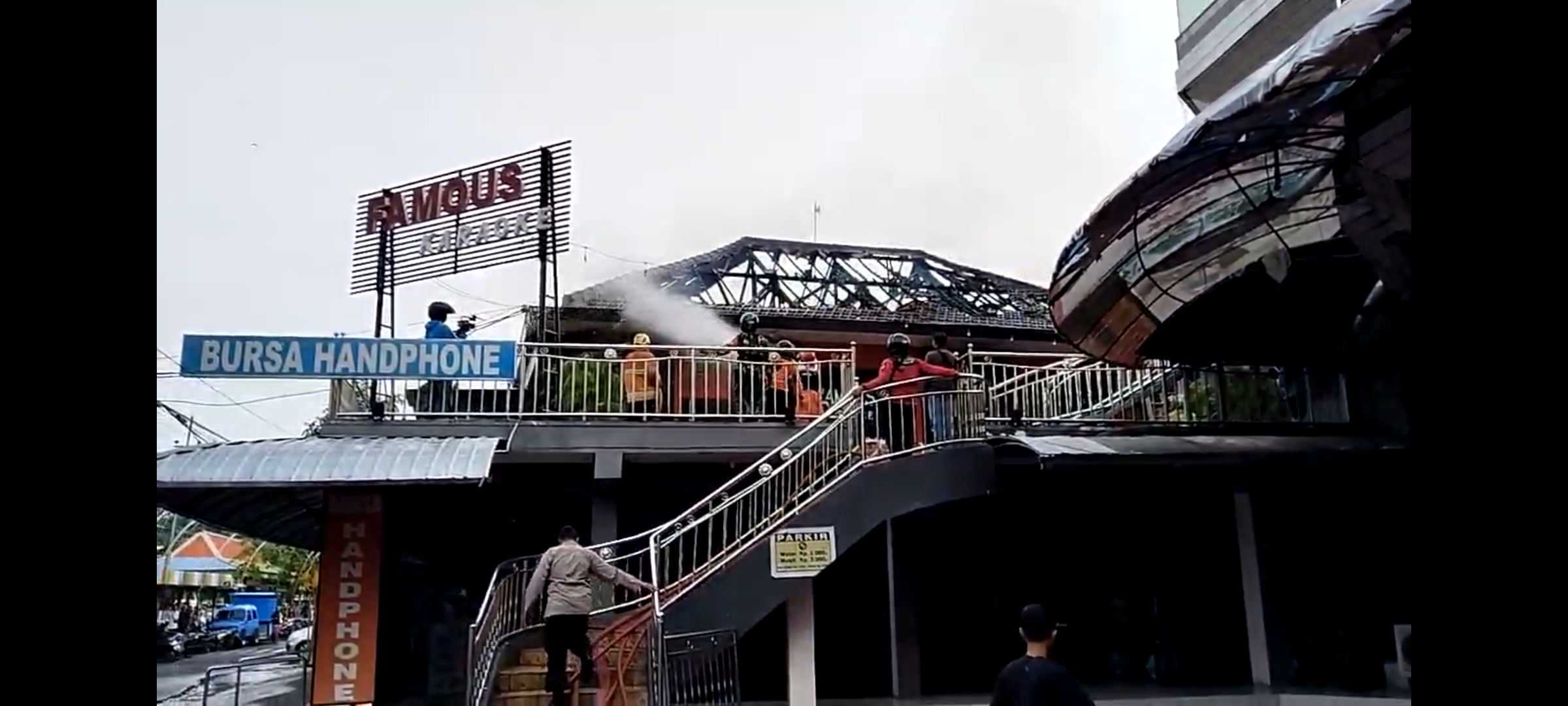 PADAMKAN API: Petugas berupaya memadamkan api di Famous Cafe & Karaoke di Presiden Plaza, Kota Madiun, Rabu (17/1) pagi. (OKTA NUR/RADAR MADIUN)