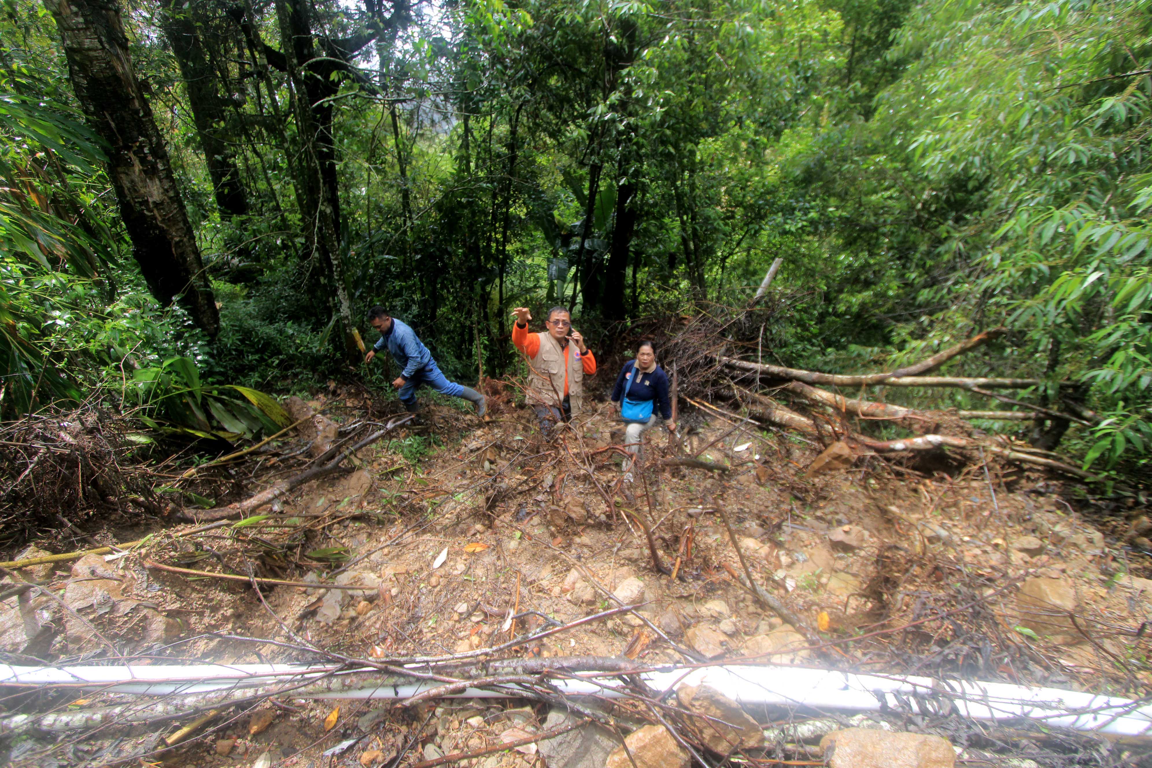 MITIGASI: Petugas gabungan meninjau lokasi longsor di bukit utara Telaga Sarangan, Jumat (19/1).