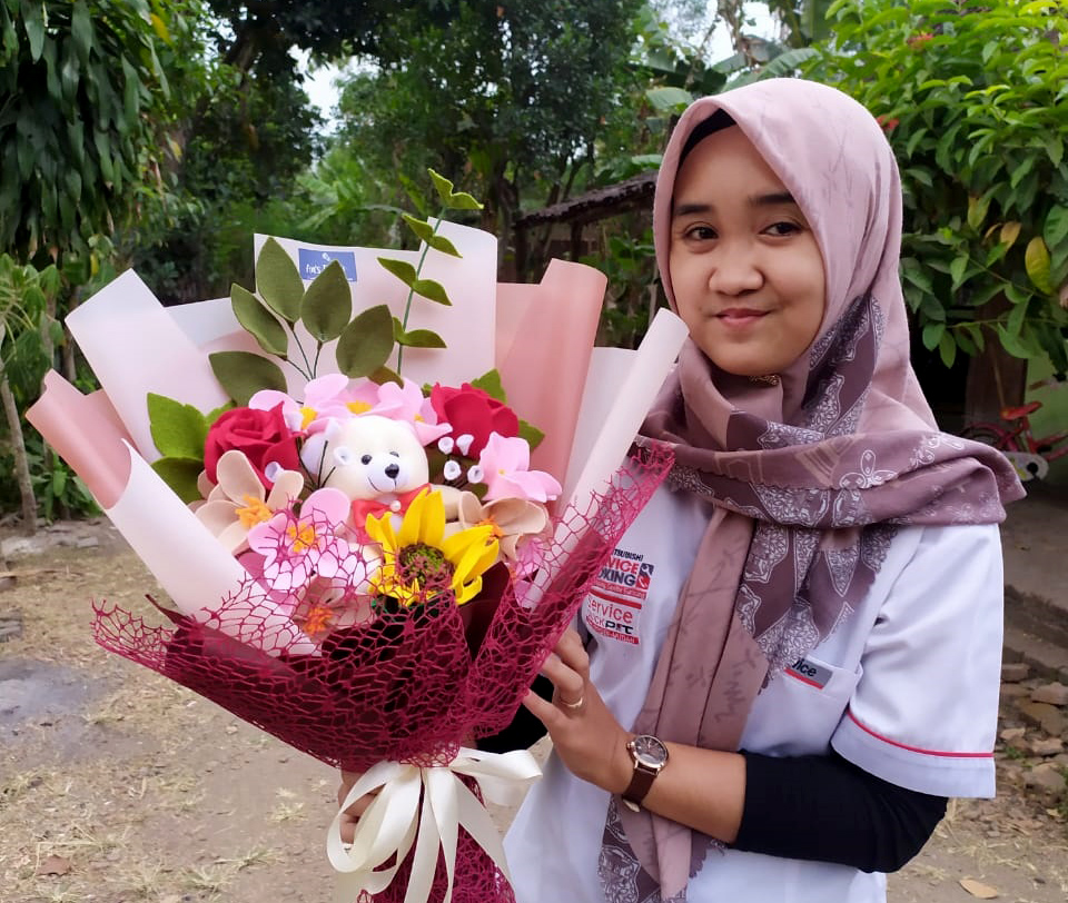 KREATIF: Sulastriani dan buket bunga flanel buatannya.&nbsp;(SULASTRIANI UNTUK RADAR MADIUN)