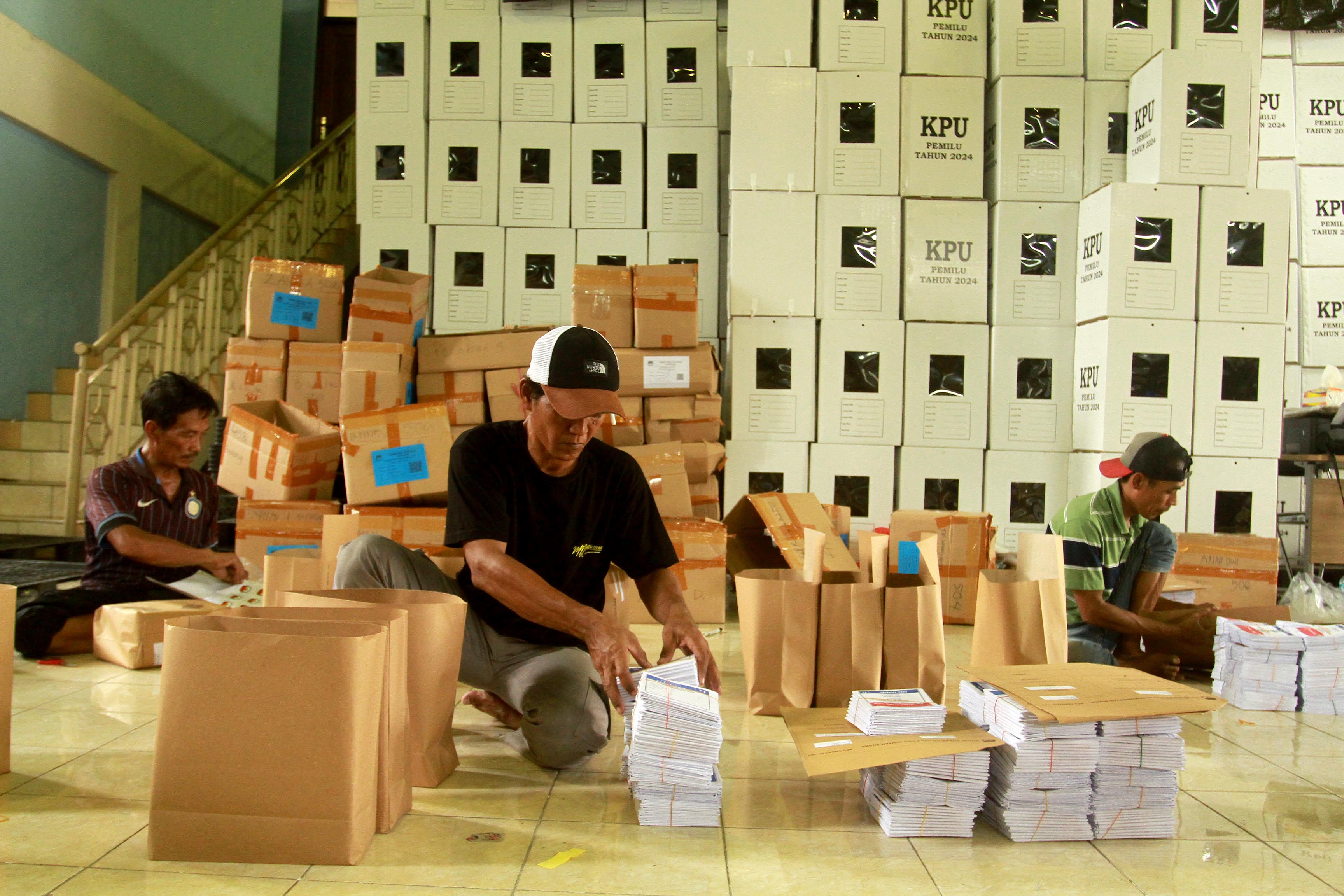 TELITI: Petugas mengemasi kebutuhan logistik Pemilu 2024 untuk masing-masing TPS di Gudang Wisma Haji Kota Madiun, Rabu (24/1).&nbsp;(BAGAS BIMANTARA/RADAR MADIUN)