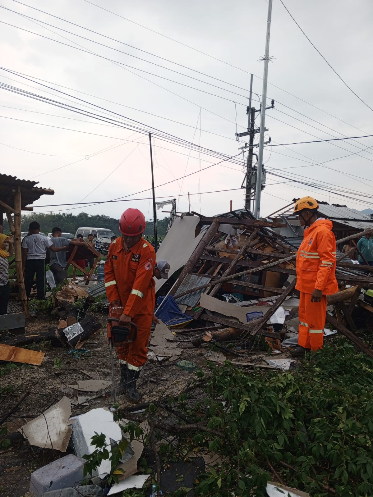 RUSAK PARAH: Petugas melakukan evakuasi pasca angin puting beliung disertai hujan deras menerjang kawasan Desa Prayungan, Kec. Sawoo, Ponorogo Jumat Sore (26/1). (ASTA YANUAR UNTUK RADAR PONOGO)