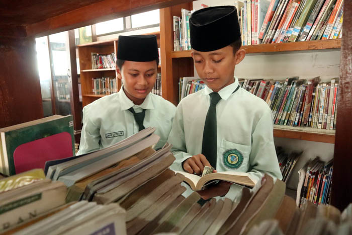 JENDELA DUNIA: Sejumlah anak-anak antusias membaca di perpusda kemarin (26/1).