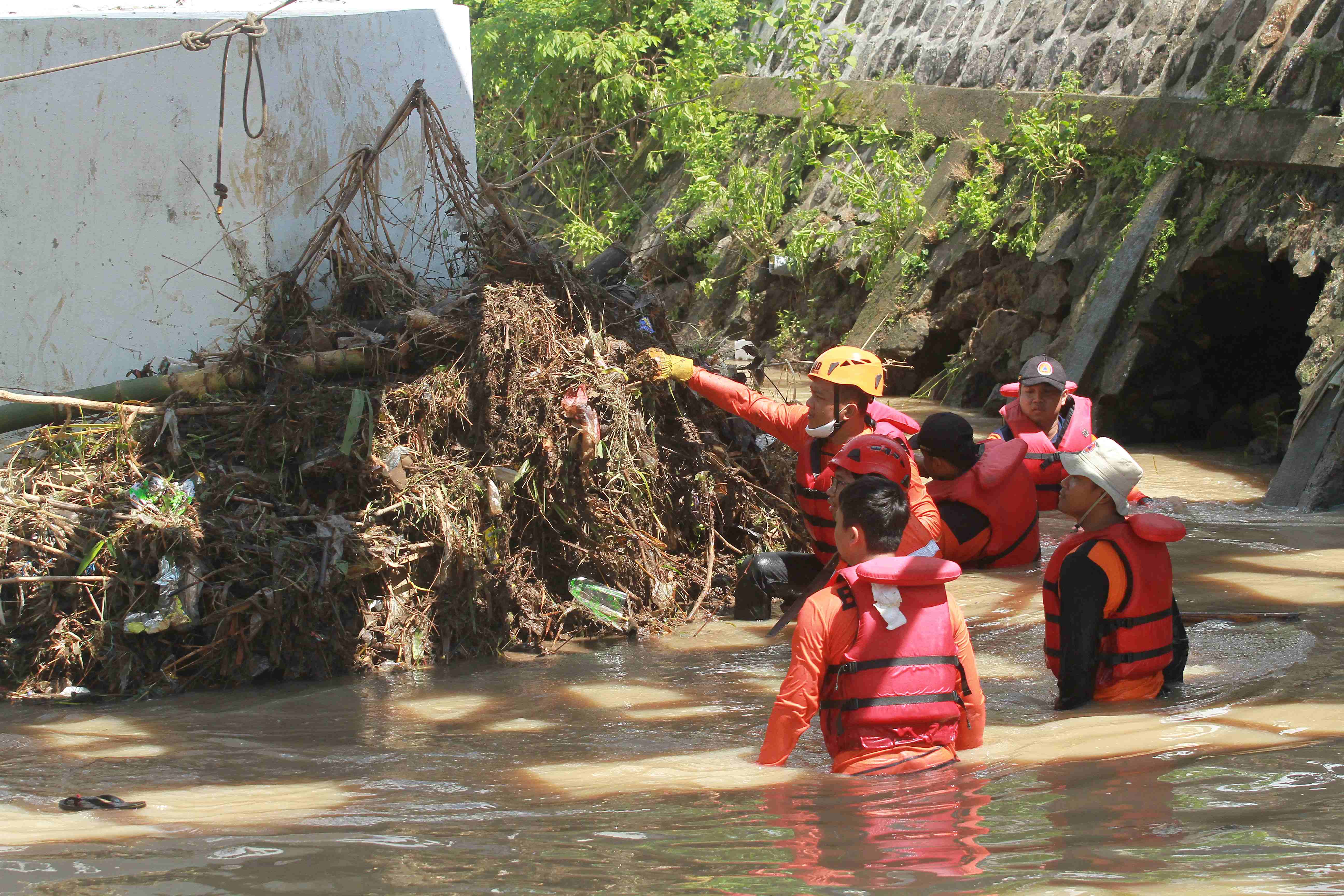 BIANG BANJIR: Petugas DPUPR Kota Madiun mengangkat sampah bambrongan yang menyumbat aliran Kali Piring di Kelurahan Pilangbango, Kecamatan Kartoharjo, Minggu (28/1).&nbsp;(BAGAS BIMANTARA/RADAR MADIUN)