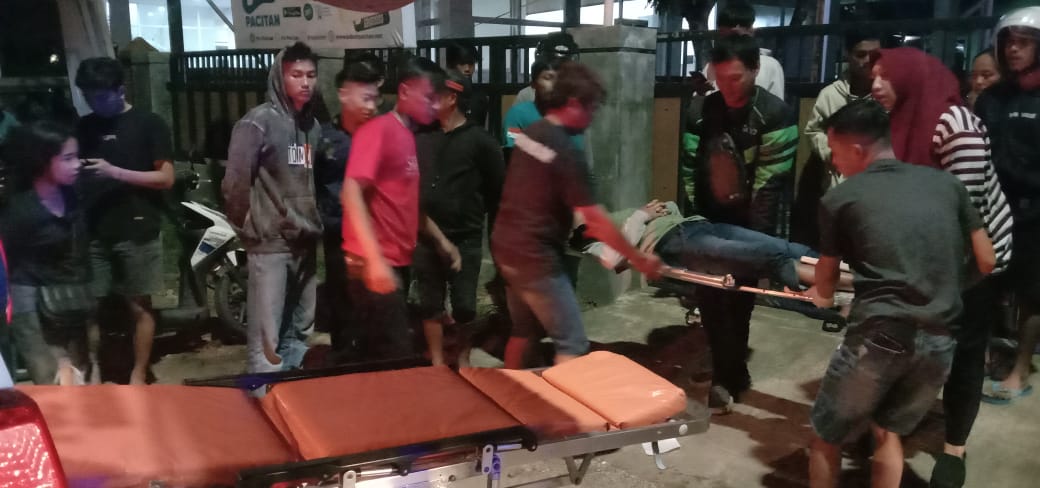 PATAH TULANG: Petugas bersama warga menolong korban laka lantas di depan Sekretariat DPC PDIP Pacitan, Minggu (28/1) dini hari. (POLRES PACITAN)