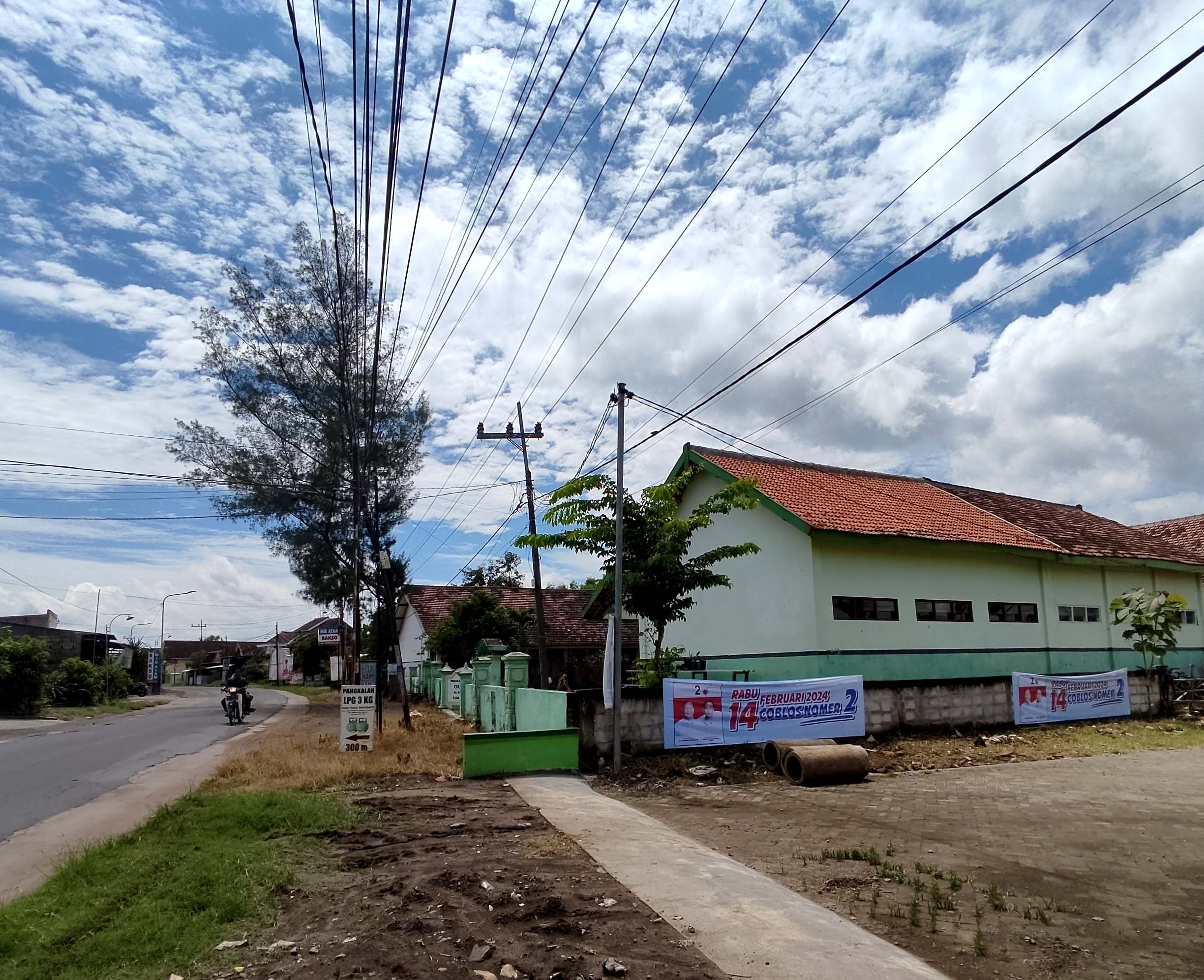 NGAWUR: Dua APK peserta Pemilu 2024 terpasang di pagar SDN 3 Dimong.&nbsp;(LODITYA FERNANDEZ/RADAR MADIUN)
