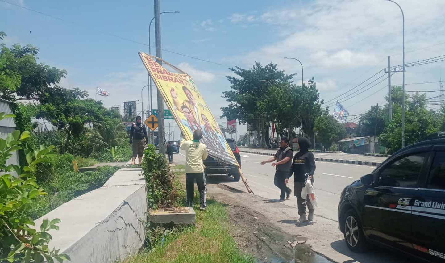 COPOT: Petugas satpol PP mencopot APK bergambar Gibran dan Prabowo, sebelum masa tenang. (SATPOL PP UNTUK RADAR MADIUN)