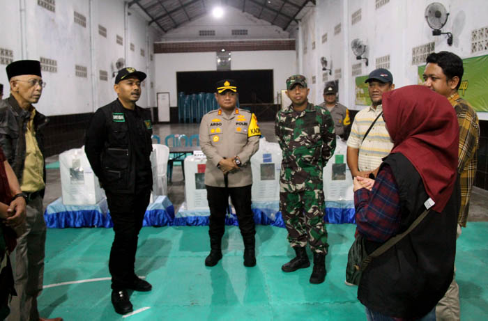 PATROLI: Bupati Ngawi Ony Anwar Harsono dan anggota Forkopimda Ngawi mengecek kesiapan sejumlah TPS, Selasa (13/2) malam.