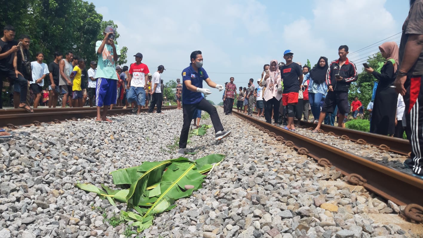 TRAGIS: Petugas mengevakuasi jasad Sri Wahyuni di perlintasan kereta api di Desa Wonokerto, Kedunggalar,&nbsp;Kamis (15/2) kemarin.