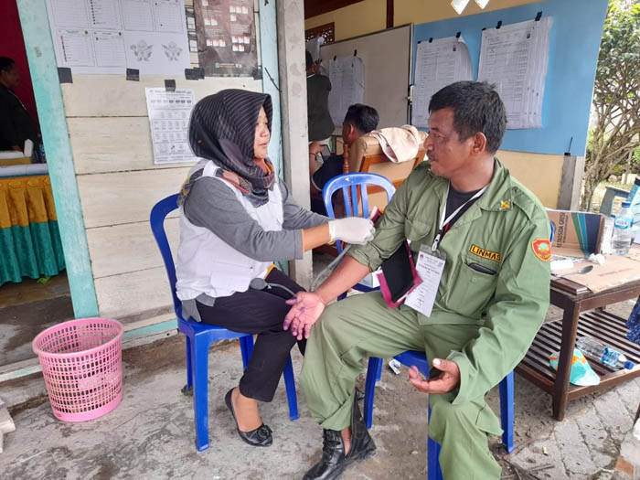 CEKATAN: Petugas medis memeriksa kesehatan salah satu petugas penyelenggara pemungutan suara di Ngawi, Rabu (14/2) kemarin.