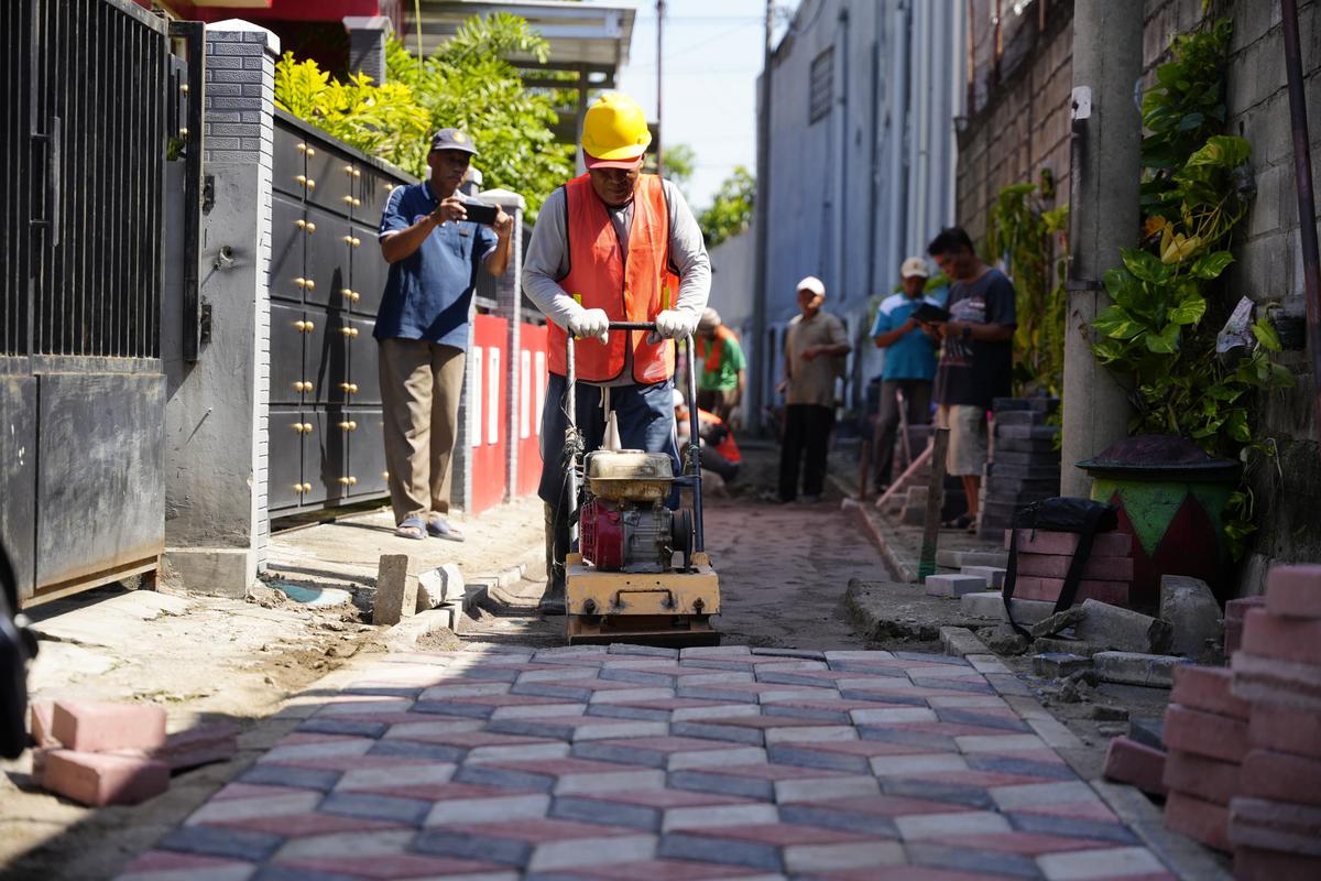 PROYEK FISIK: Program pavingisasi jalan dan gang lingkungan tahun ini mulai berjalan. (DISKOMINFO FOR JAWA POS RADAR MADIUN)