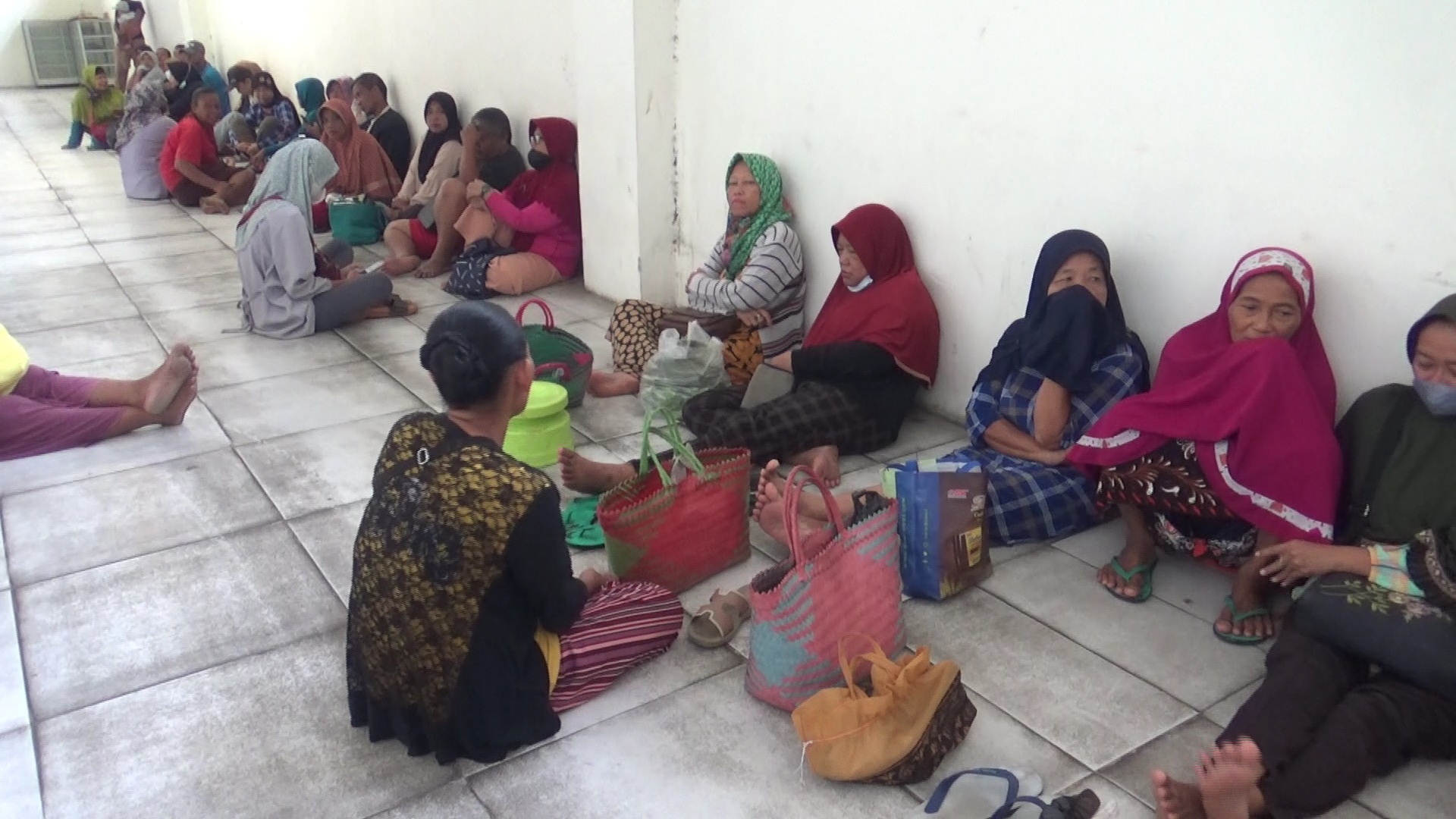 GOLEK MURAH: Puluhan warga ngenteni neng ngarep kios beras PBN sing durung bukak saperlu oleh beras murah. (ASEP SYAEFUL BACHRI/RADAR MADIUN)