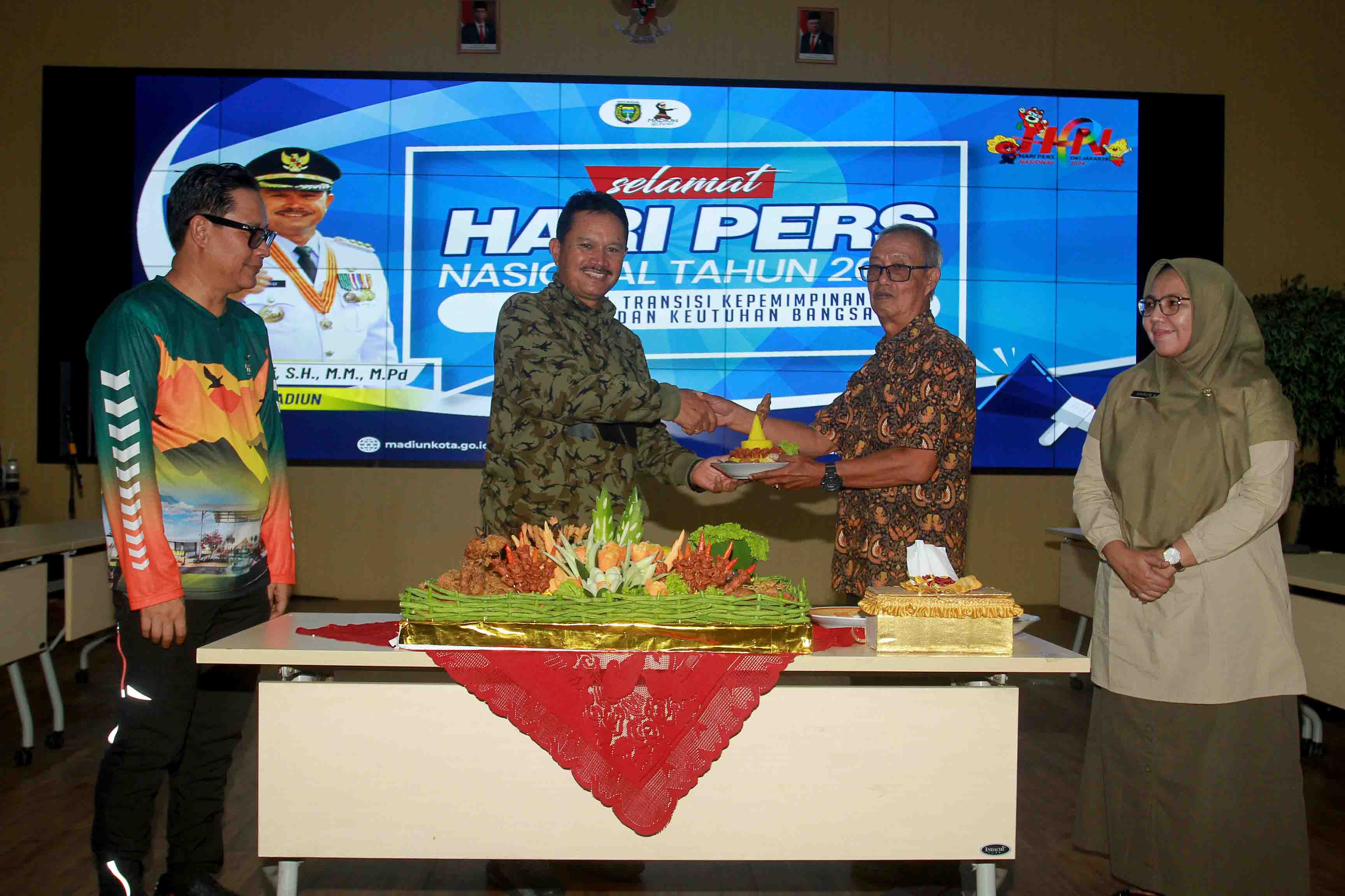 SEDERHANA: Wali Kota Madiun melakukan potong tumpeng sebagai simbolis memperingati HPN 2024 di Gedung GCIO, Jumat (23/2). (BAGAS BIMANTARA/JAWA POS RADAR MADIUN)