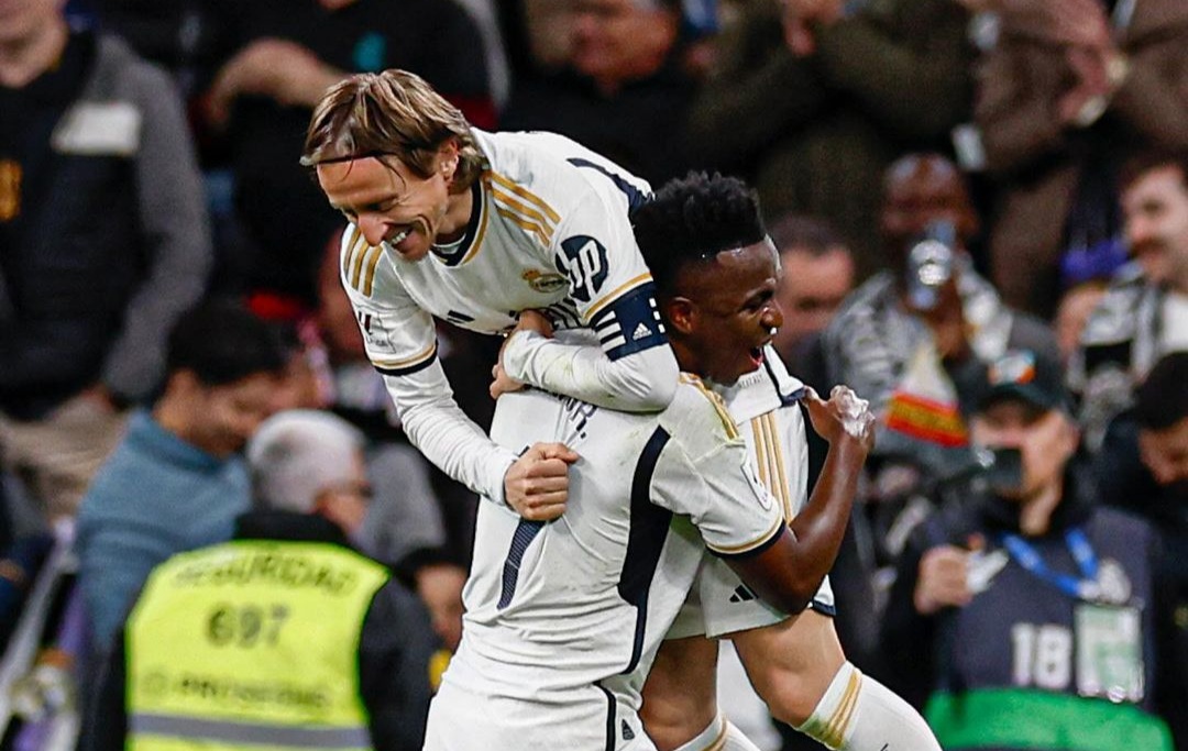 Luka Modric digendong Vinicius Junior usai mencetak gol.