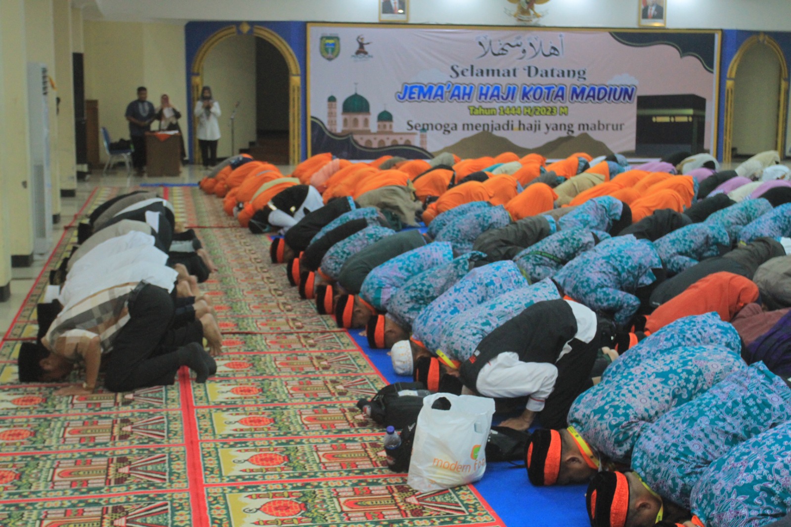 MABRUR: Para jemaah melakukan sujud syukur sekembalinya ke Tanah Air setelah menunaikan ibadah haji pada tahun lalu. (BAGAS BIMANTARA/RADAR MADIUN)