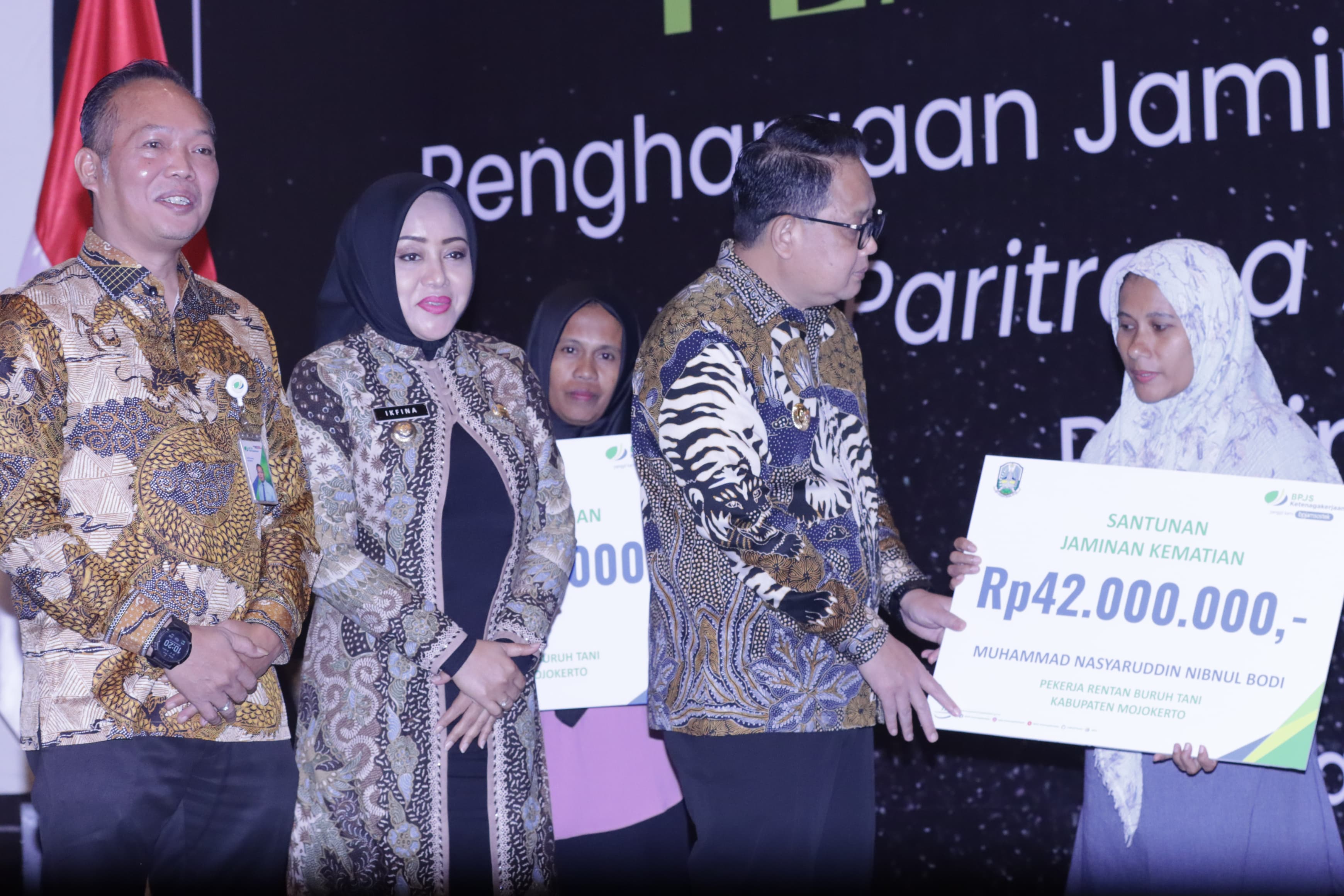 BERI SANTUNAN: Pj Gubernur Jatim Adhy Karyono menyerahkan santunan di sela acara Paritrana Award Jatim 2023. (HUMAS PEMPROV JATIM)