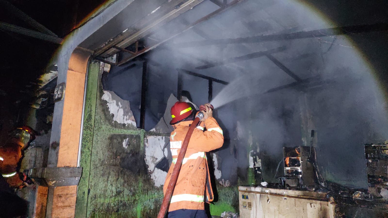 LUDES: Petugas damkar melakukan upaya pendinginan di kompleks ruko yang terbakar di Jalan Salak Senin (4/3) dini hari. (BAGAS BIMANTARA/JAWA POS RADAR MADIUN)