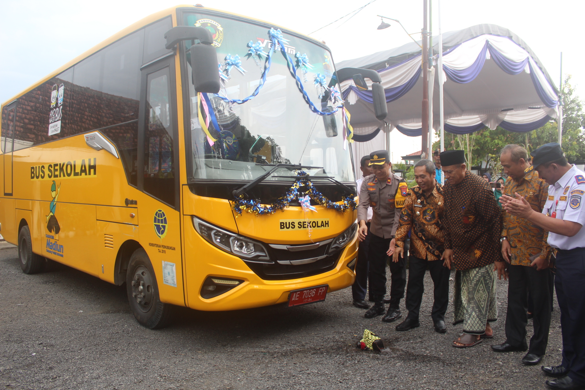 BANTU PELAJAR: Tontro bersama Pj Sekda Sodik Hery Purnomo, Kadishub Supriyadi dan tamu undangan lainnya meresmikan bus sekolah dengan pemecahan kendi. (TITIS OSI/RADAR MADIUN)