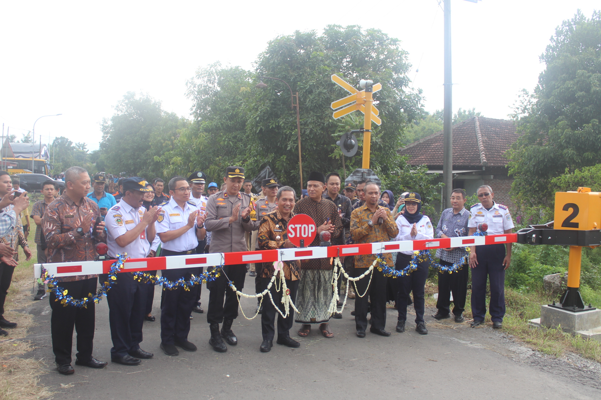 TERJAMIN: Pj Bupati Madiun Tontro Pahlawanto memotong pita tanda peresmian palang perlintasan sebidang di Dusun Kopen, Desa Sidorejo, Saradan, Jumat (8/3). (TITIS OSI/RADAR MADIUN)