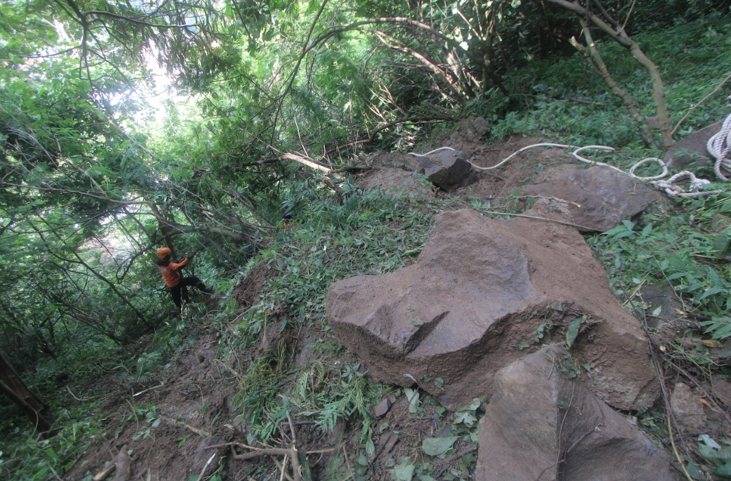 JUMBO: Petugas BPBD memeriksa bongkahan bebatuan yang tersangkut di tebing di Dusun Ngrejeng, Desa Puntukdoro, Kecamatan Plaosan, Jumat (8/3). (AJI SAPUTRA/RADAR MAGETAN)