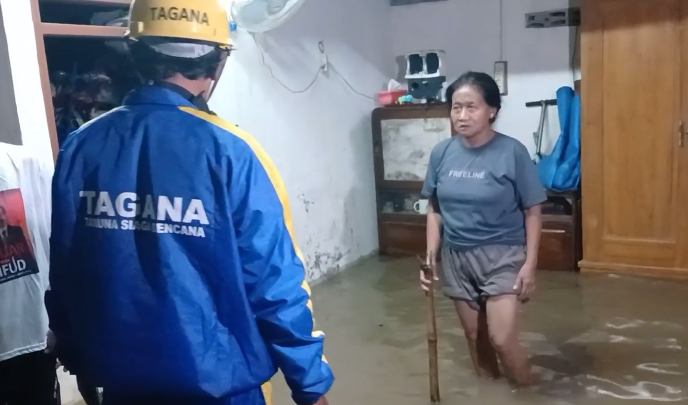 TERGENANG: Tagana memeriksa genangan di salah satu rumah di Kedungrejo, Pilangkenceng, Madiun, Sabtu (9/3) malam. (R. BAGUS RAHADI/RADAR MADIUN)