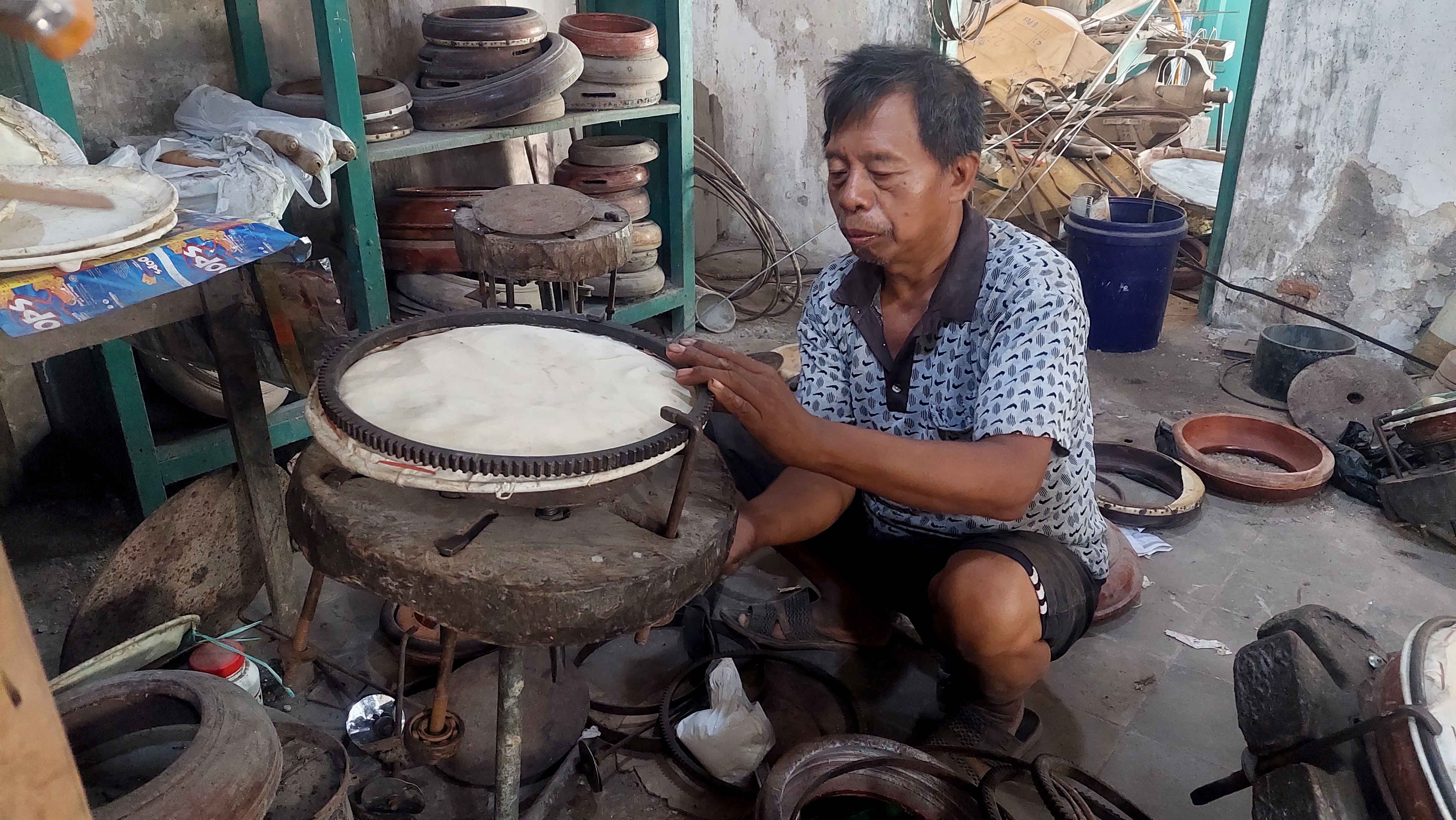 ALAT MUSIK: Sutari mempressing rebana di bengkelnya di Desa Ngetrep, Kecamatan Jiwan Kabupaten Madiun. (DIAN RAHAYU/RADAR MADIUN)