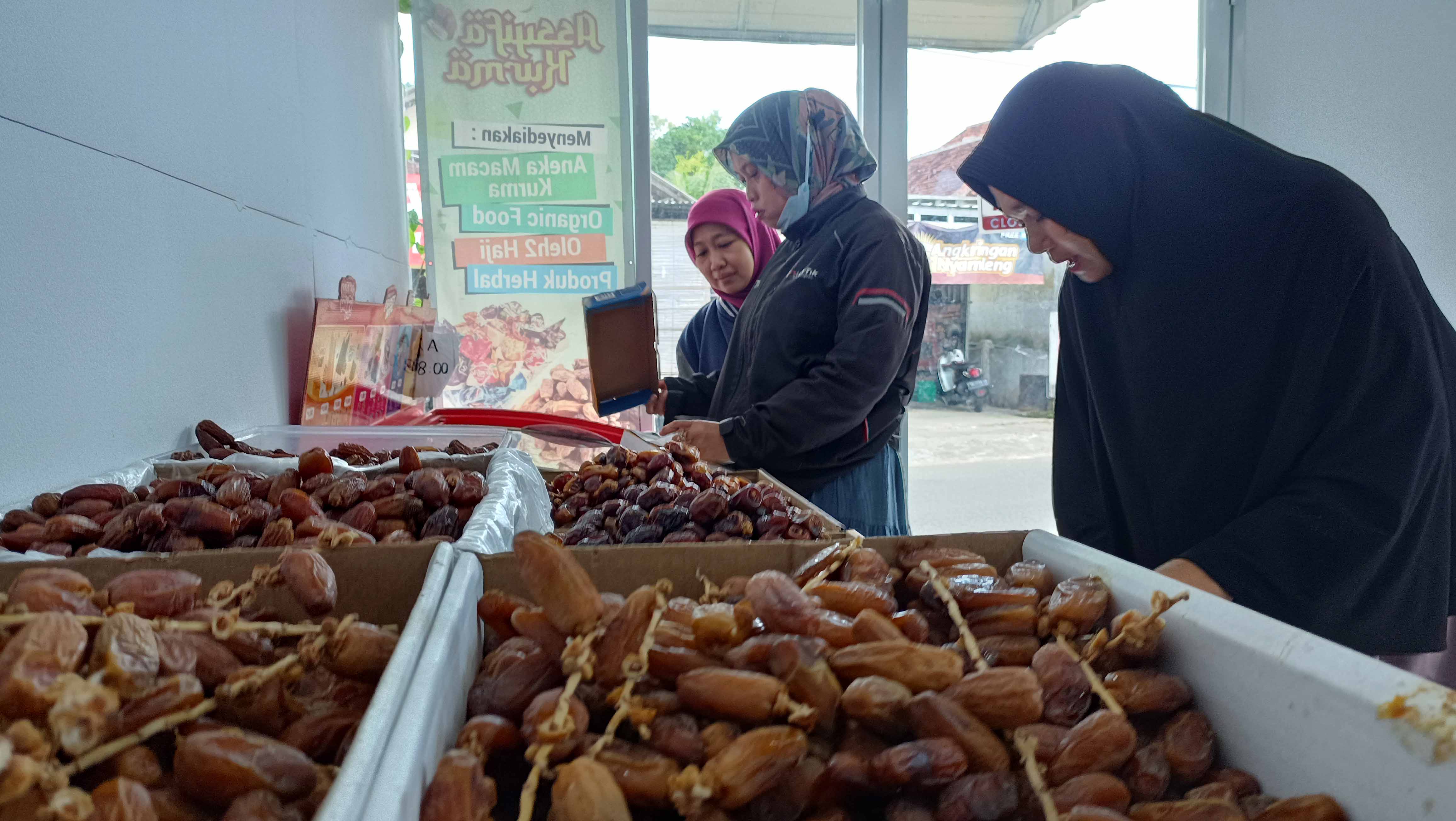 BUAH ARAB: Hetti Kistiwi, pedagang kurma di Kelurahan Baleharjo, Pacitan, omzetnya mencapai puluhan juta rupiah memasuki Ramadan kali ini. (NUR CAHYONO/RADAR PACITAN)