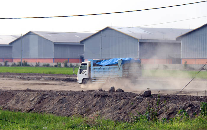 PROSES PEMBANGUNAN: Aktivitas truk di lahan yang bakal dibangun pabrik mainan di Kecamatan Geneng.