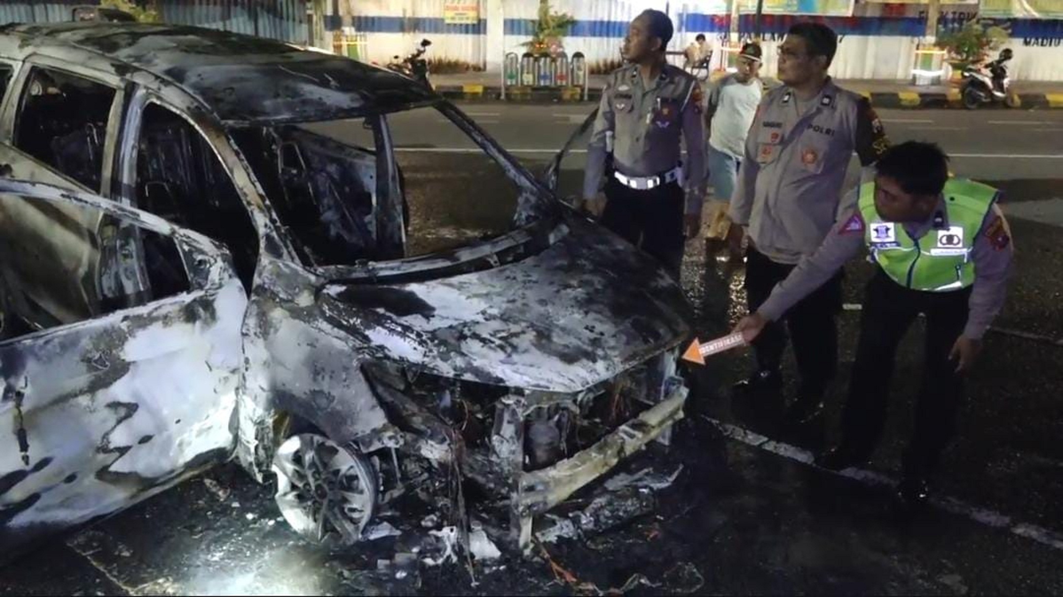 KARI RANGKA: Petugas Satlantas Polres Madiun Kota ngolah TKP mobil kobong wingi (26/3). (HENGKY RISTANTO/RADAR MADIUN)