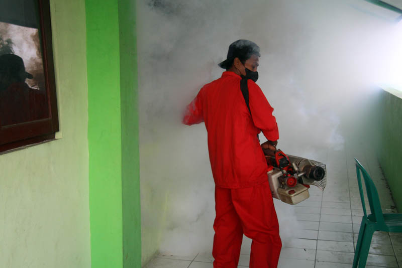 PENGASAPAN: Petugas Dinkes Ngawi melakukan fogging ke lingkungan SDN 1 Margomulyo buntut meninggalnya salah satu siswa akibat terjangkit DBD, Rabu (27/3).
