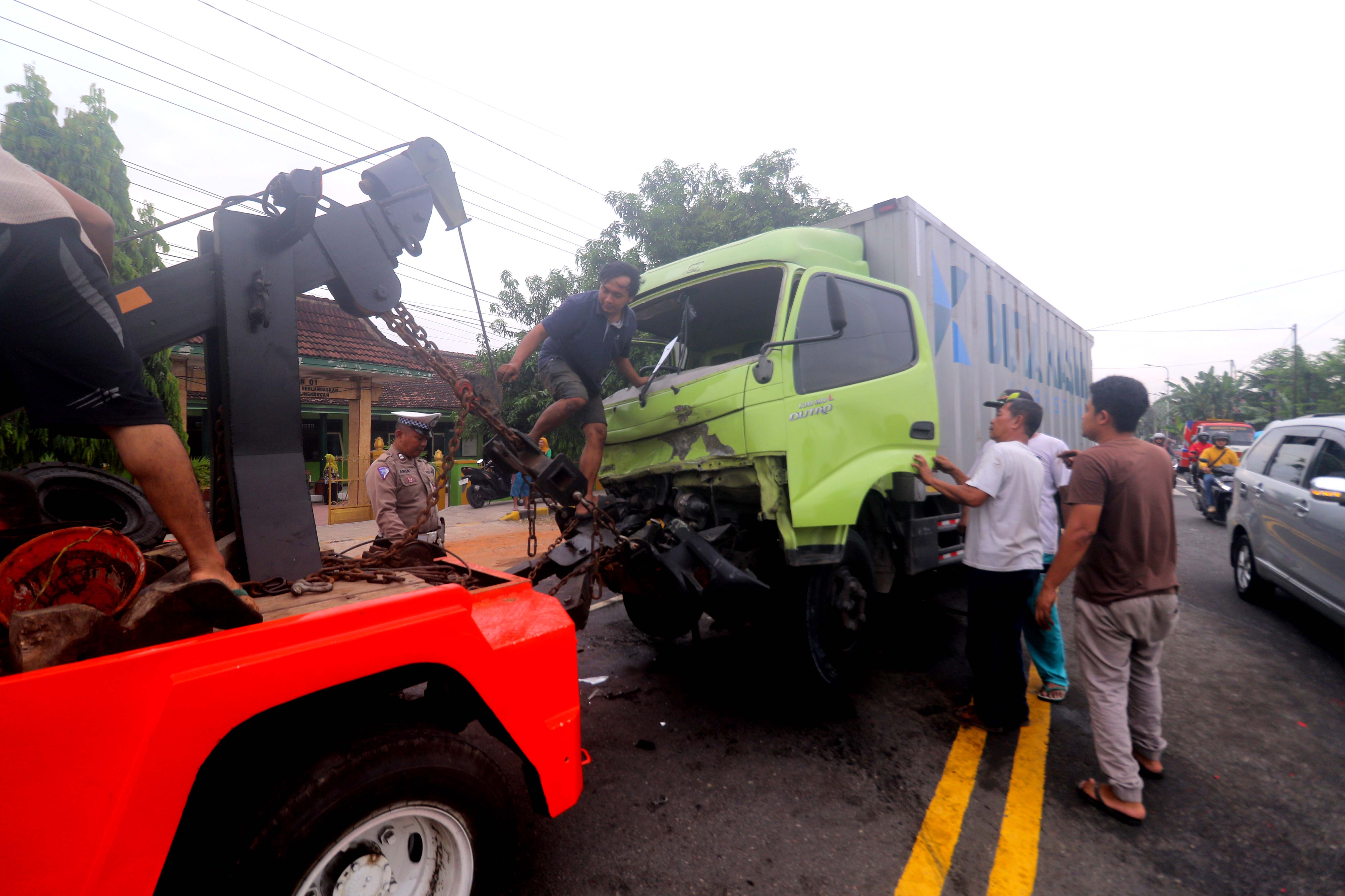 DIEVAKUASI: Dua kendaraan ringsek diderek pasca terlibat kecelakaan di Jalan Raya Madiun-Surabaya, Desa Garon, Balerejo. (R. BAGUS RAHADI/RADAR MADIUN)
