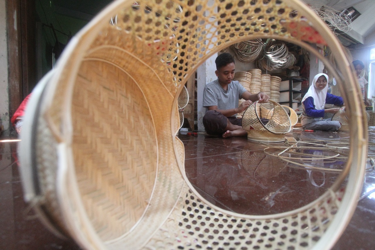 PRODUKTIF: Para pekerja kerajinan keranjang bambu maksimalkan produksi untuk memenuhi ribuan pesanan jelang Lebaran.&nbsp;(AJI PUTRA/RADAR MAGETAN)