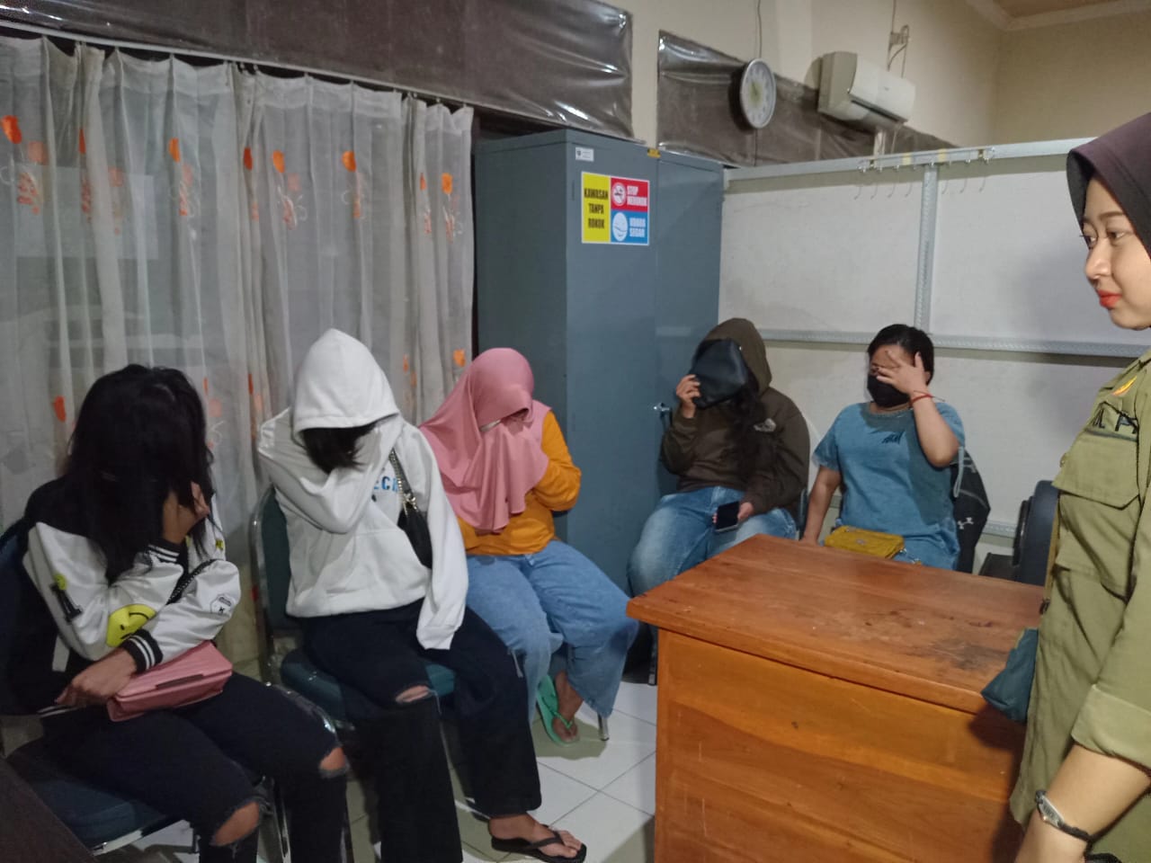 TEPERGOK PETUGAS RAZIA: Salah satu dari lima pasang bukan pasutri yang tertangkap basah berduaan di dalam kamar kos di Ngawi, Minggu (31/3) malam. (ASEP SYAEFUL BACHRI/RADAR NGAWI)