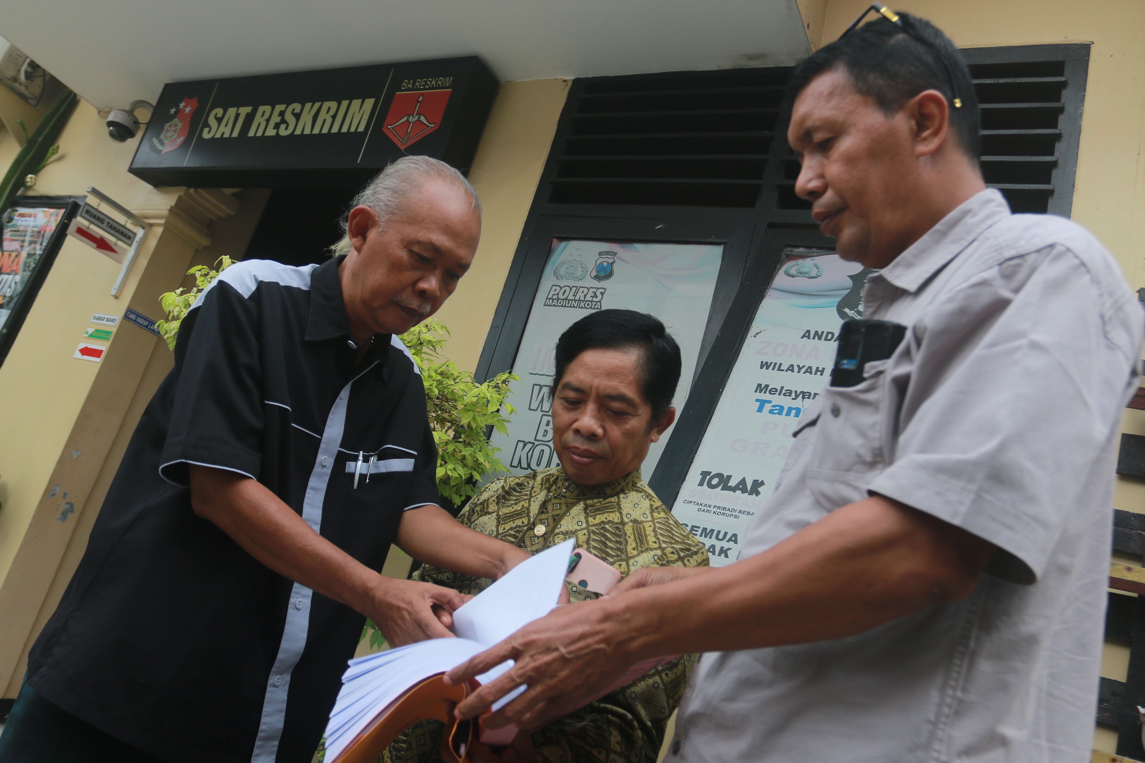 LAPOR PAK: Mahfudz Daroini (pakaian batik), mantan Dekan Fakultas Ilmu Sosial dan Ilmu Politik (FISIP) Ummad ke Satreskrim Polres Madiun Kota kemarin (1/4).&nbsp;(BAGAS BIMANTARA/RADAR MADIUN)
