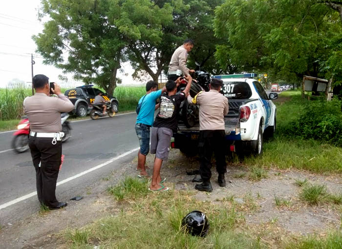 TABRAKAN: Petugas mengangkut motor Vario yang terlibat laka lantas dengan truk dam di Jalan Raya Ngawi-Maospati kemarin.