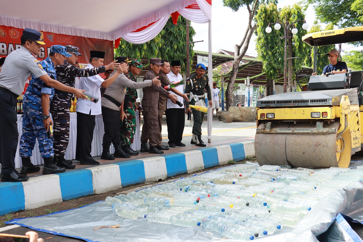 DIGILAS: Ratusan botol miras ilegal, barang bukti hasil Operasi Pekat Ramadan dimsunahkan kemarin (3/4). (NUR CAHYONO/RADAR MADIUN)
