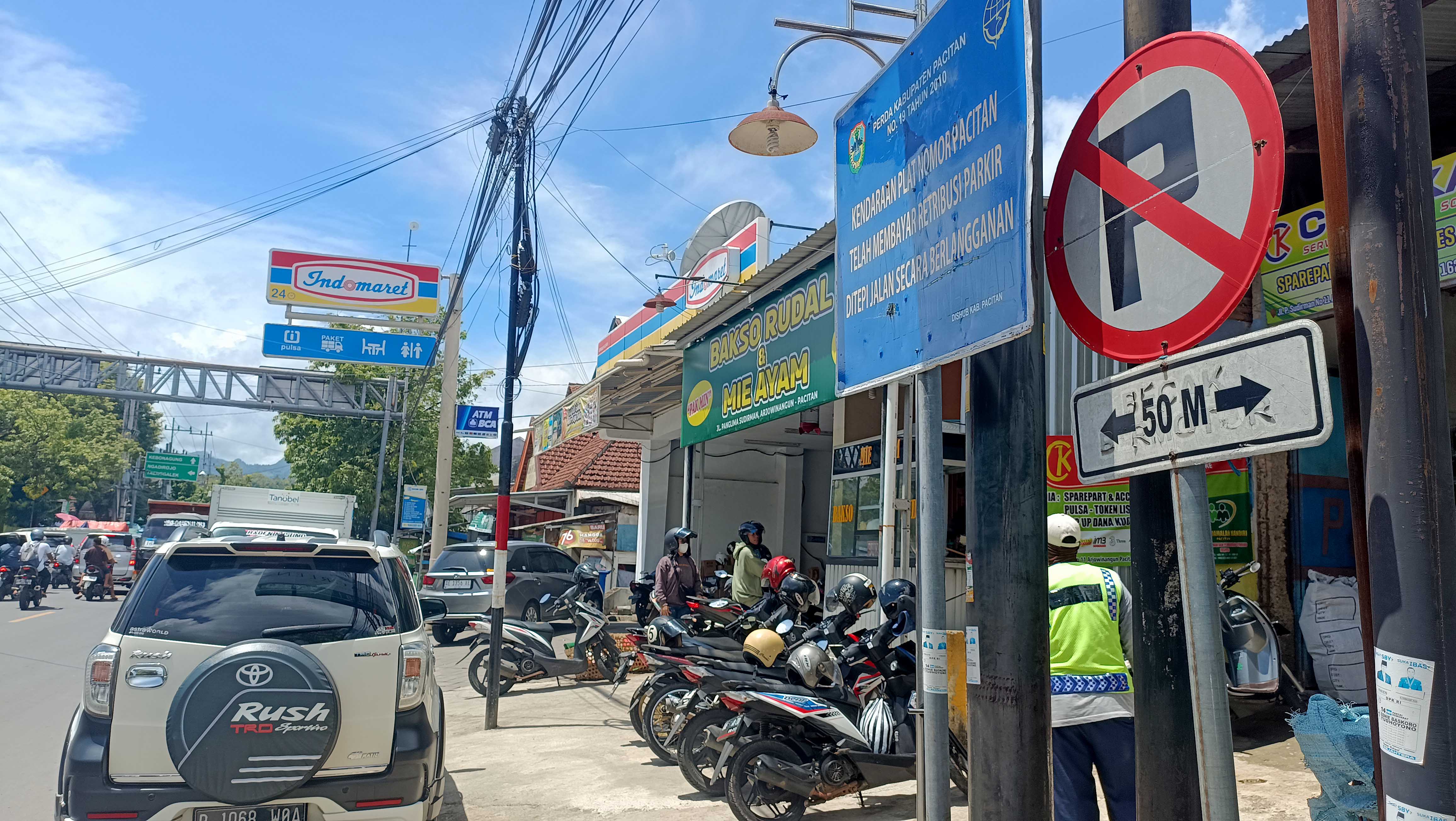 MANFAATKAN MOMEN: Rambu larangan parkir di Jalan Panglima Sudirman Pacitan tidak diindahkan para juru parkir liar dadakan jelang Lebaran. (NUR CAHYONO/RADAR PACITAN)