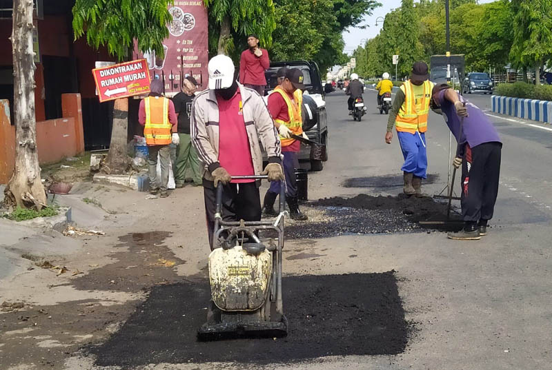 PEMELIHARAAN: Petugas DPUPKP Ponorogo melakukan perbaikan jalan rusak jelang lebaran.