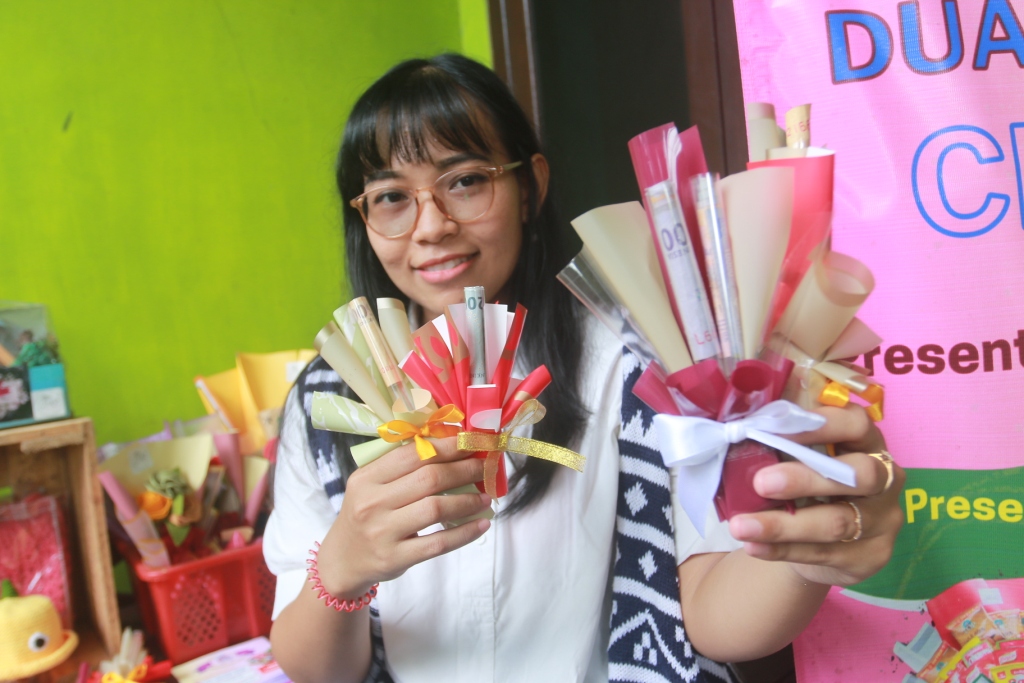 TANGAN KREATIF: Mevi Rudiani menunjukkan buket THR khusus edisi Lebaran buatannya. (BAGAS BIMANTARA/JAWA POS RADAR MADIUN)