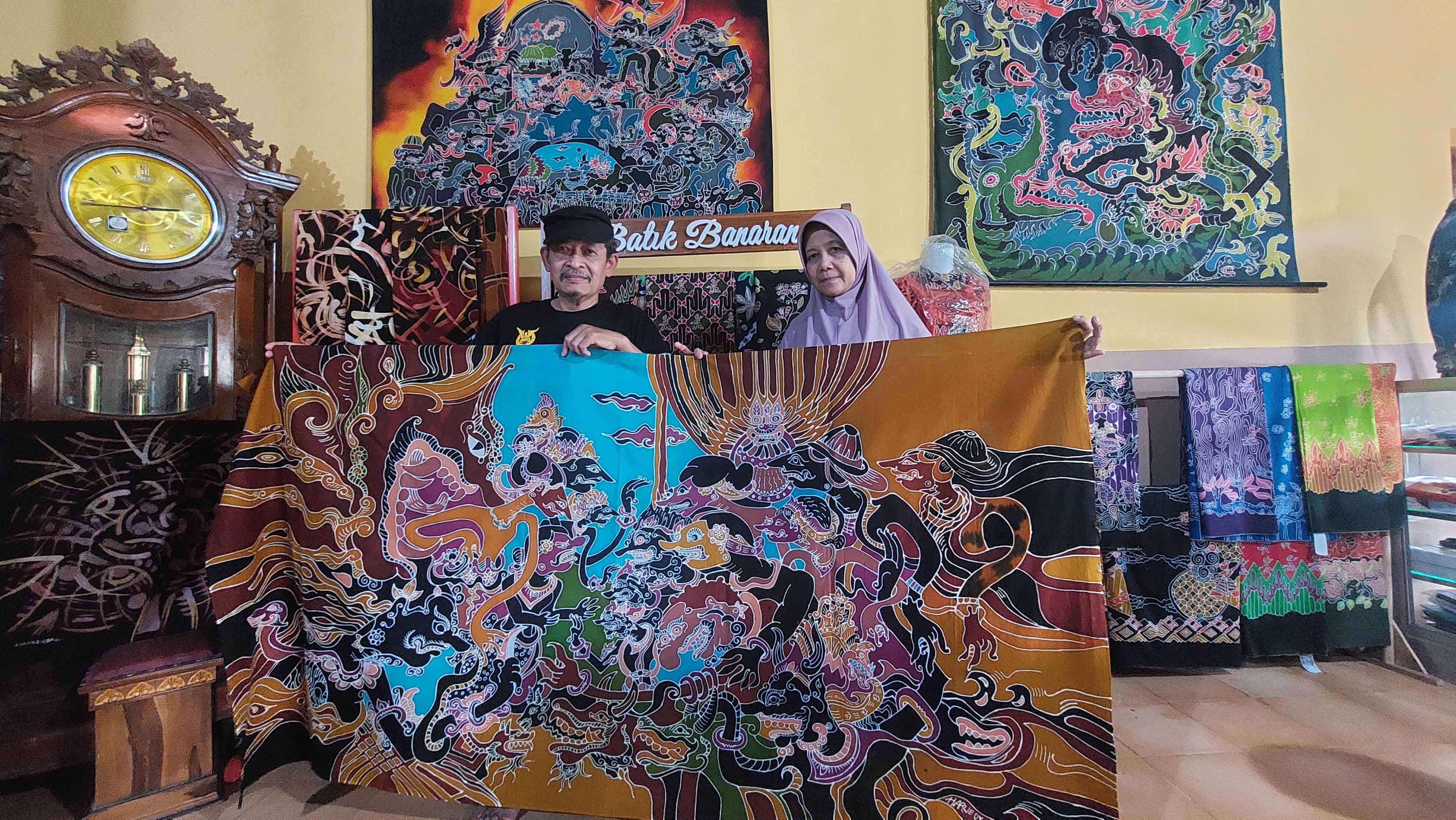 KLASIK: Suharwedi-Roikhul menunjukkan koleksi batik tulis karya mereka. (DIAN RAHAYU/JAWA POS RADAR MADIUN)